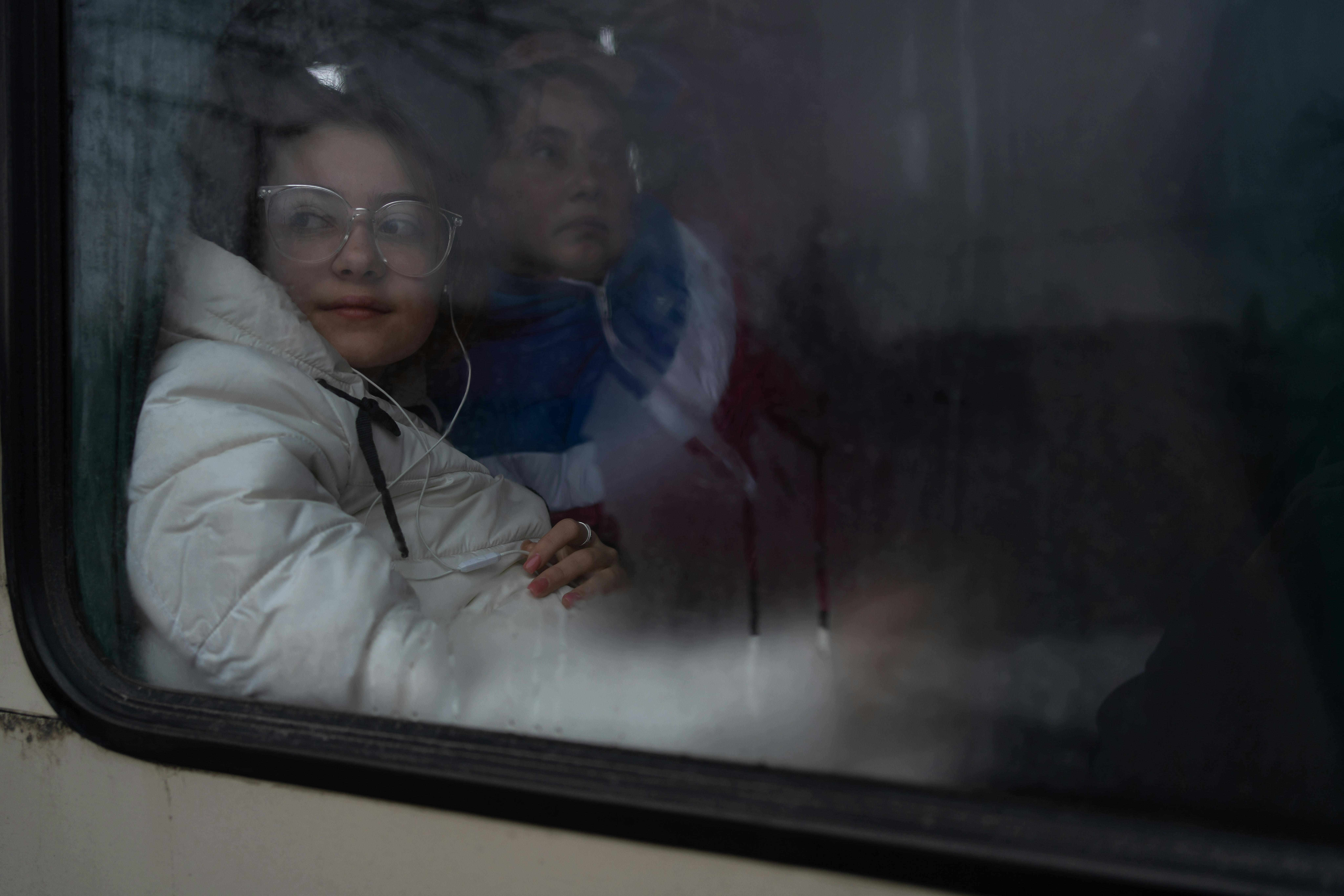 L'insegnante Yana e sua figlia Alyona, 13 anni, guardano attraverso il finestrino dell'autobus di evacuazione.