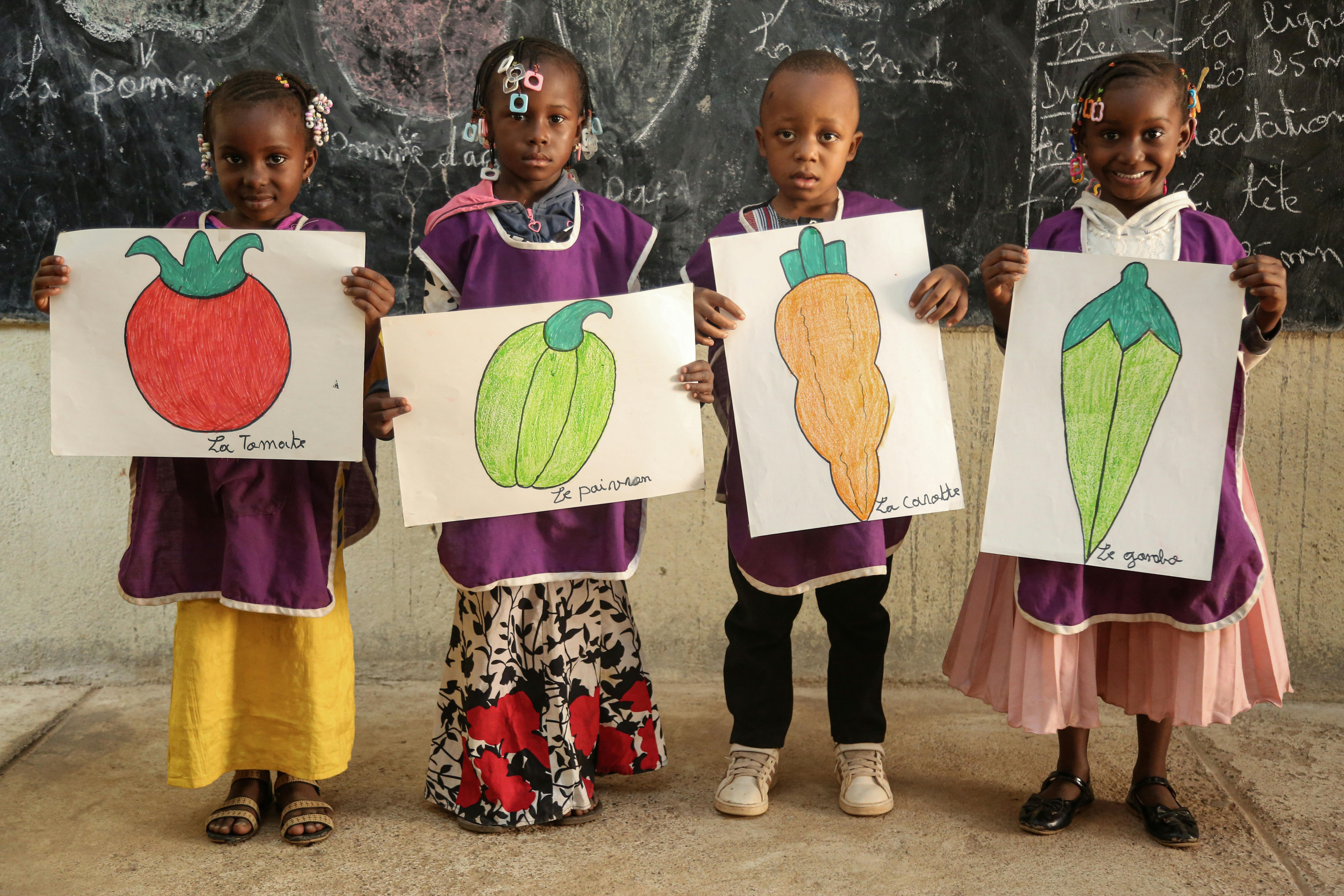I bambini mostrano alcuni disegni con i cibi nutrienti di cui hanno imparato l'importanza nel Centro di Sviluppo per la Prima Infanzia, in Mali