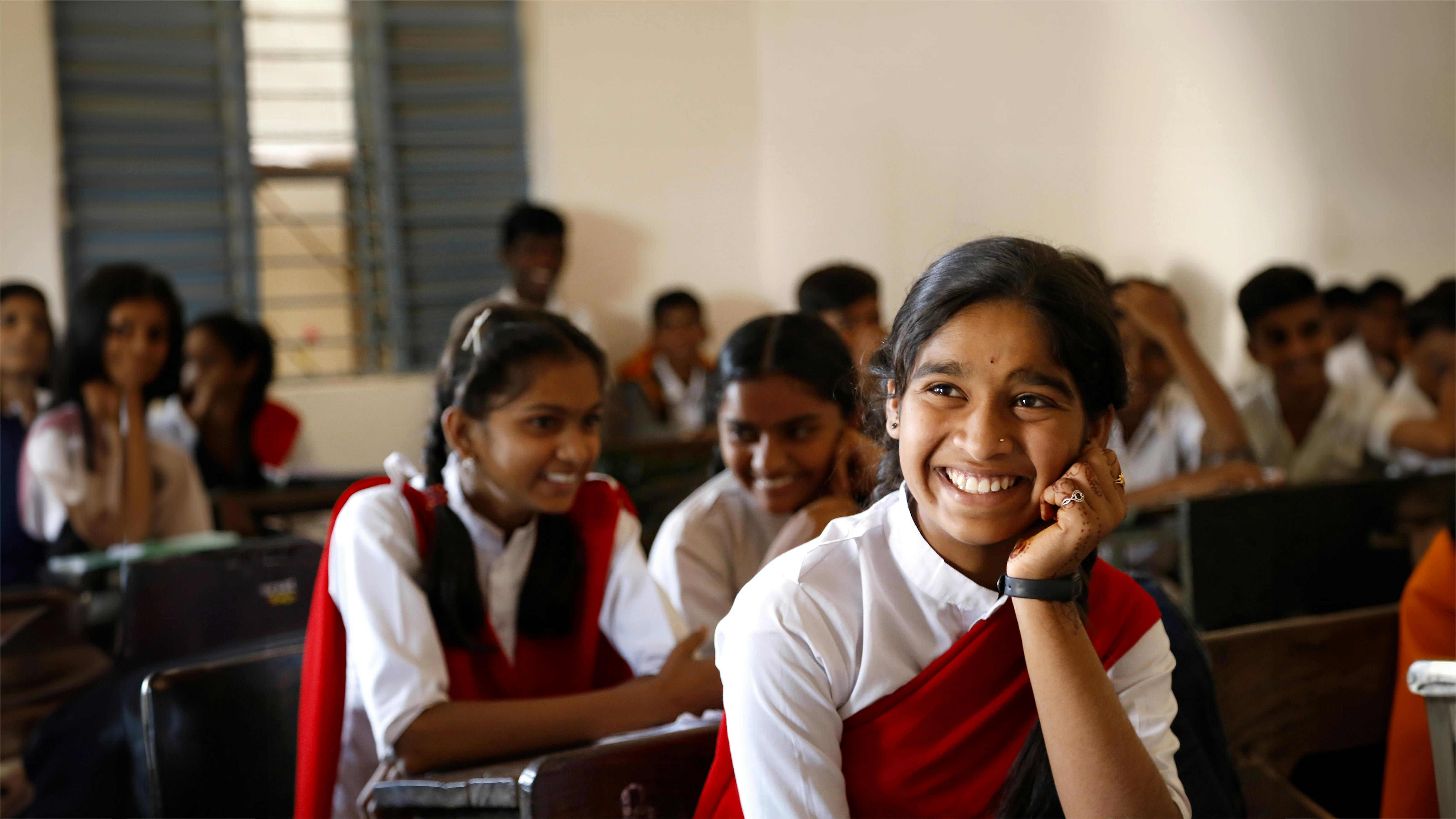 na giovane ragazza sorride mentre frequenta la sua lezione alla scuola Bhai Uddhavrao Patil Prashala nel distretto di Osmanabad nel Maharashtra, India