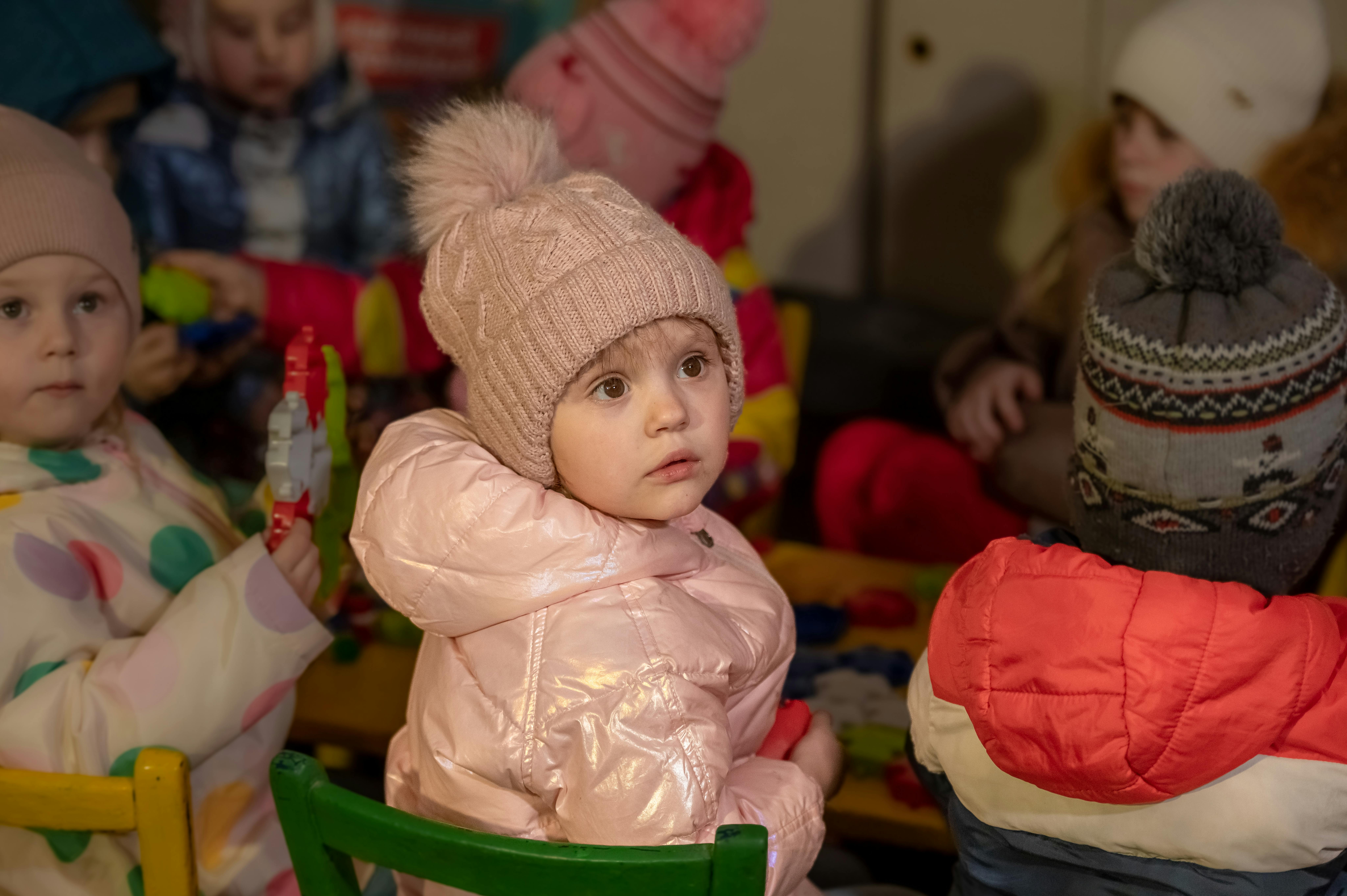 Mykolaivka, Ucraina. La bambina in età prescolare, che indossa abiti invernali, è al riparo del suo asilo.