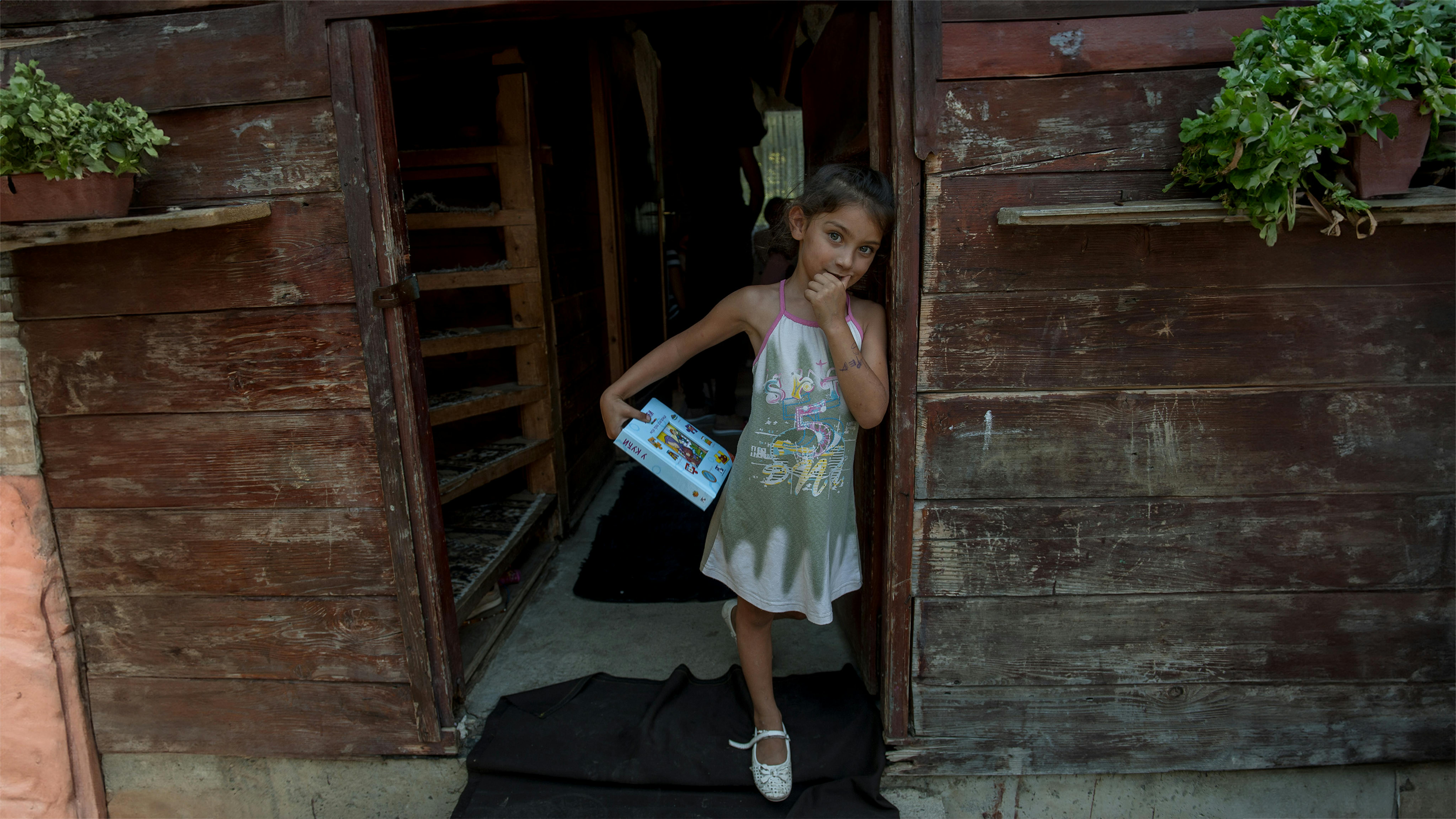 Serbia - Ragazza davanti a casa sua in un insediamento rom