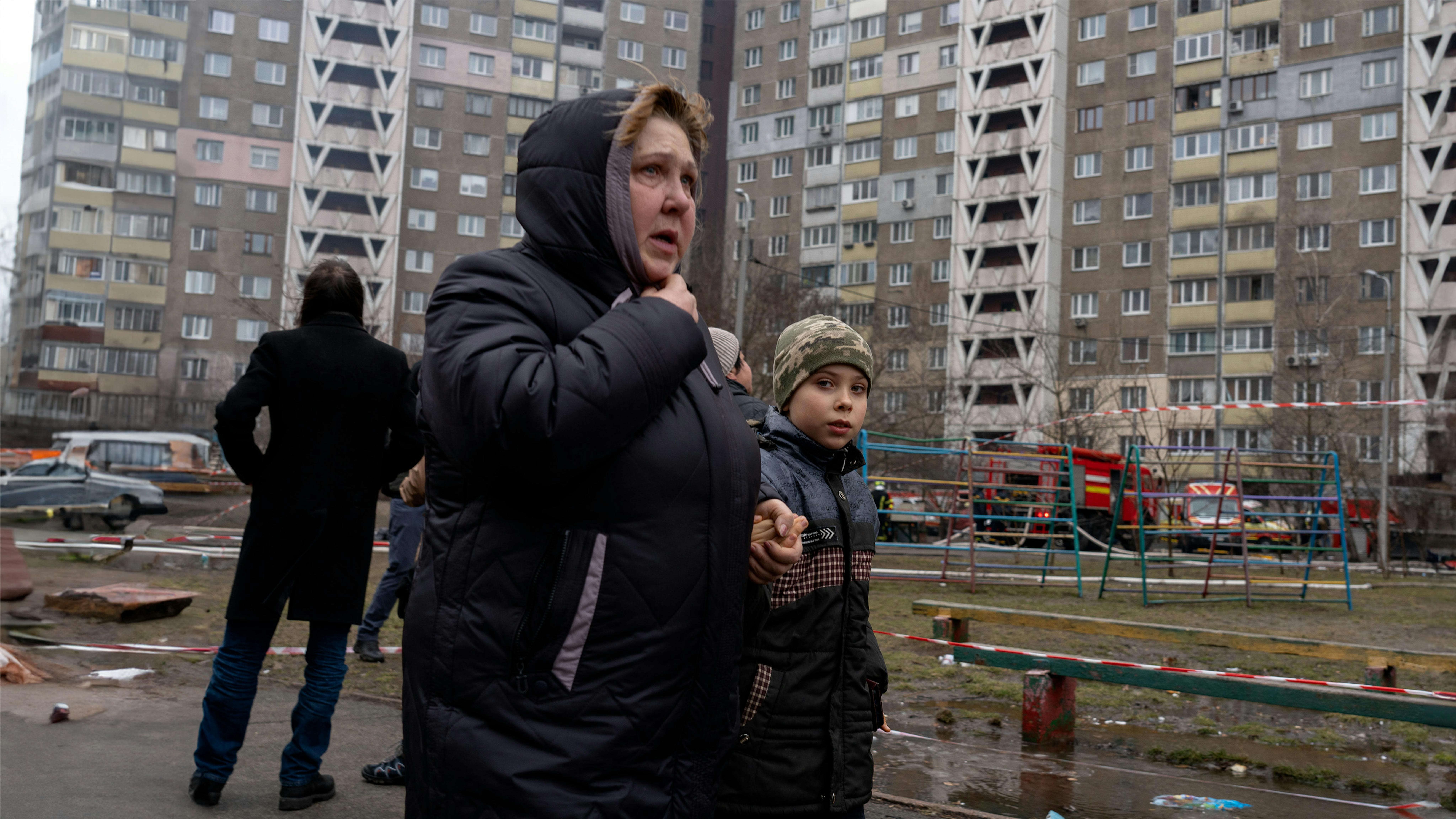 Ucraina - Una donna dall'aria spaventata tiene la mano di un ragazzo nel cortile del condominio, che questa mattina è stato colpito dal massiccio bombardamento di Kiev.