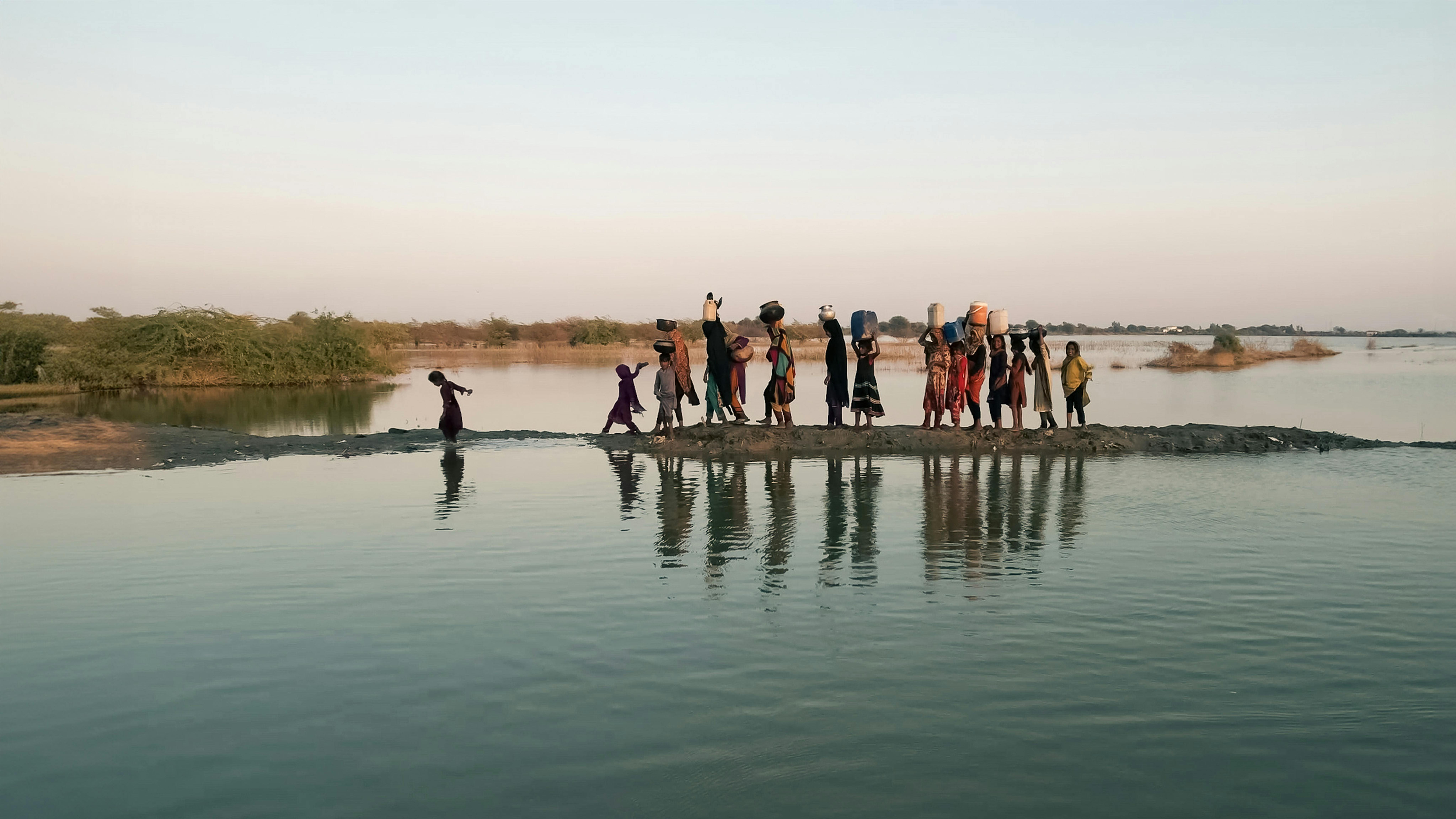 Pakistan - Donne e ragazze che camminano con i loro secchi per andare a prendere l'acqua nella regione inondata del villaggio di Geokaloi, nella provincia del Sindh