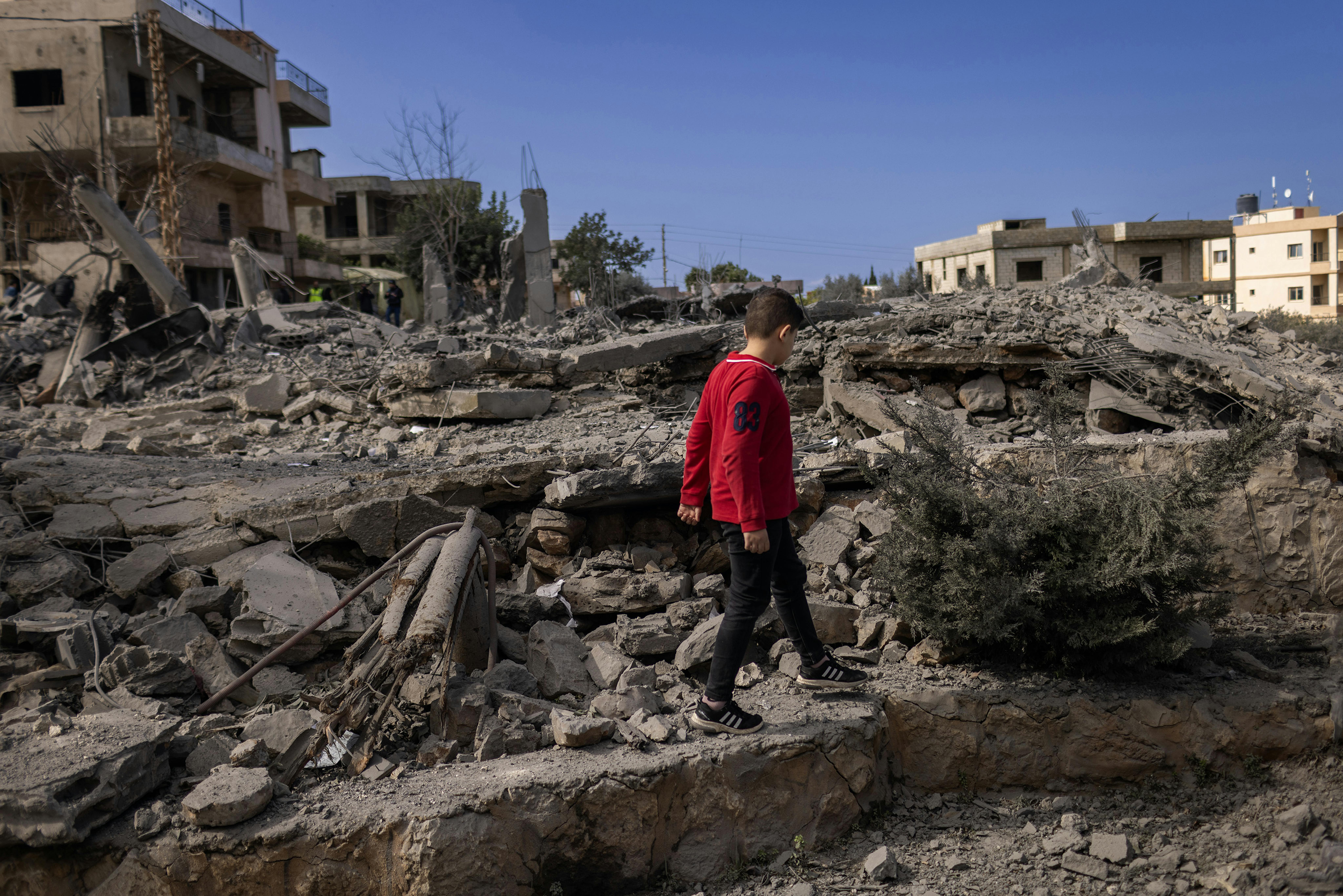 Majdal Zoun, Libano meridionale, Libano. Il 22 febbraio 2024, un giovane libanese cammina tra le rovine di una casa distrutta ieri da un attacco aereo israeliano.