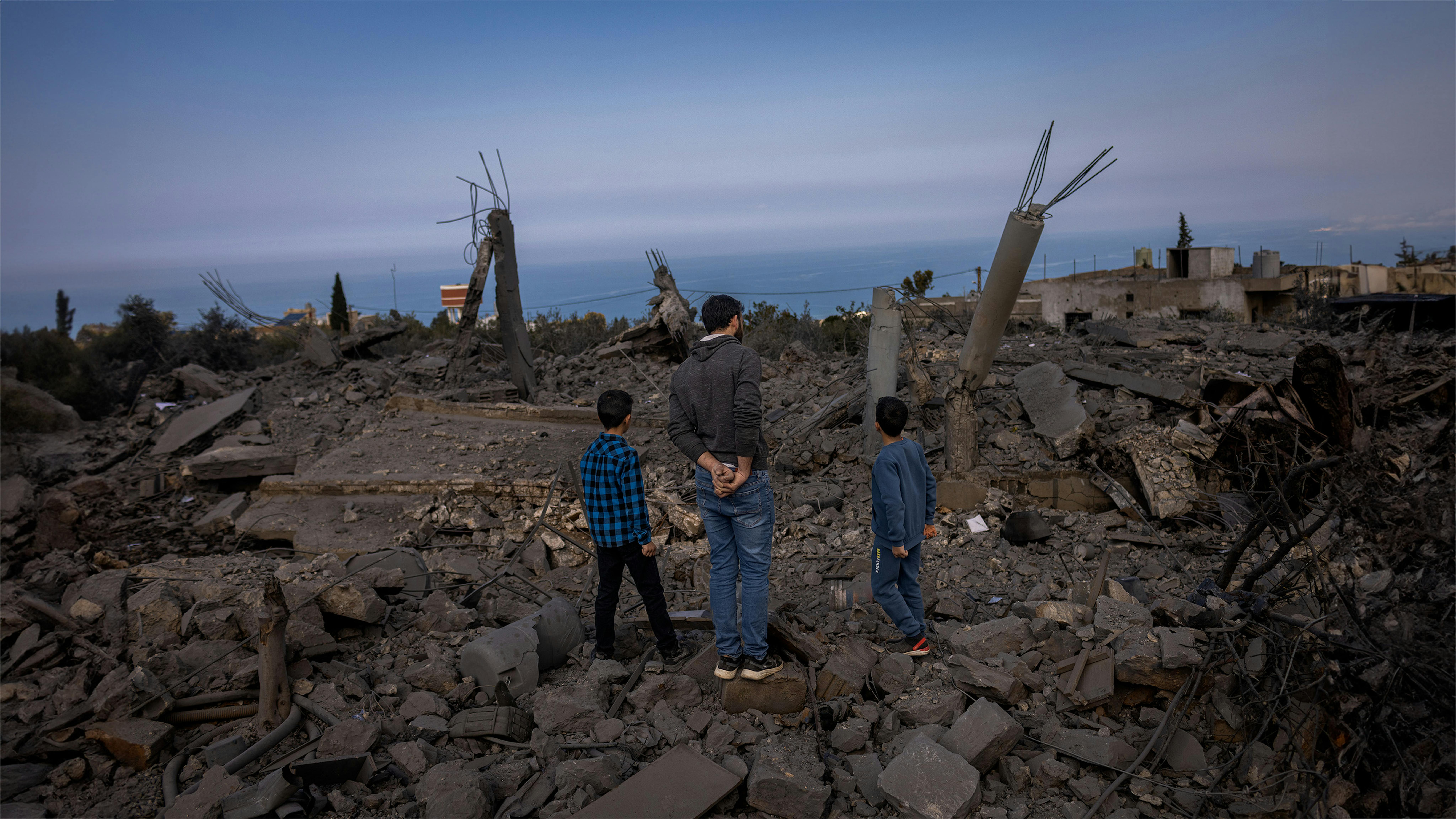 Libano - bambini e adulti tra le rovine di edifici bombardati