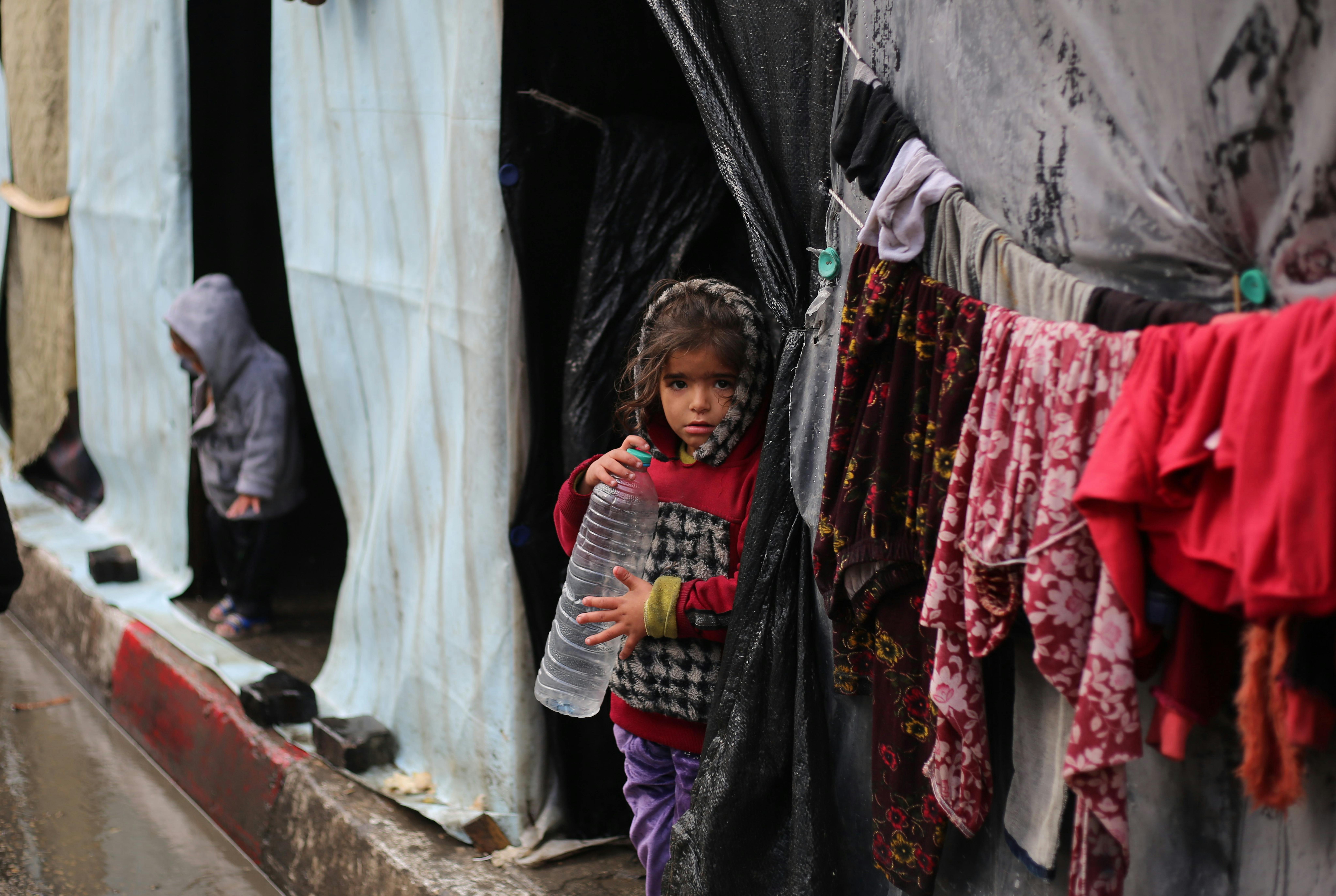 Striscia di Gaza - una bambina con una bottiglia vuota di acqua nella città di Rafah