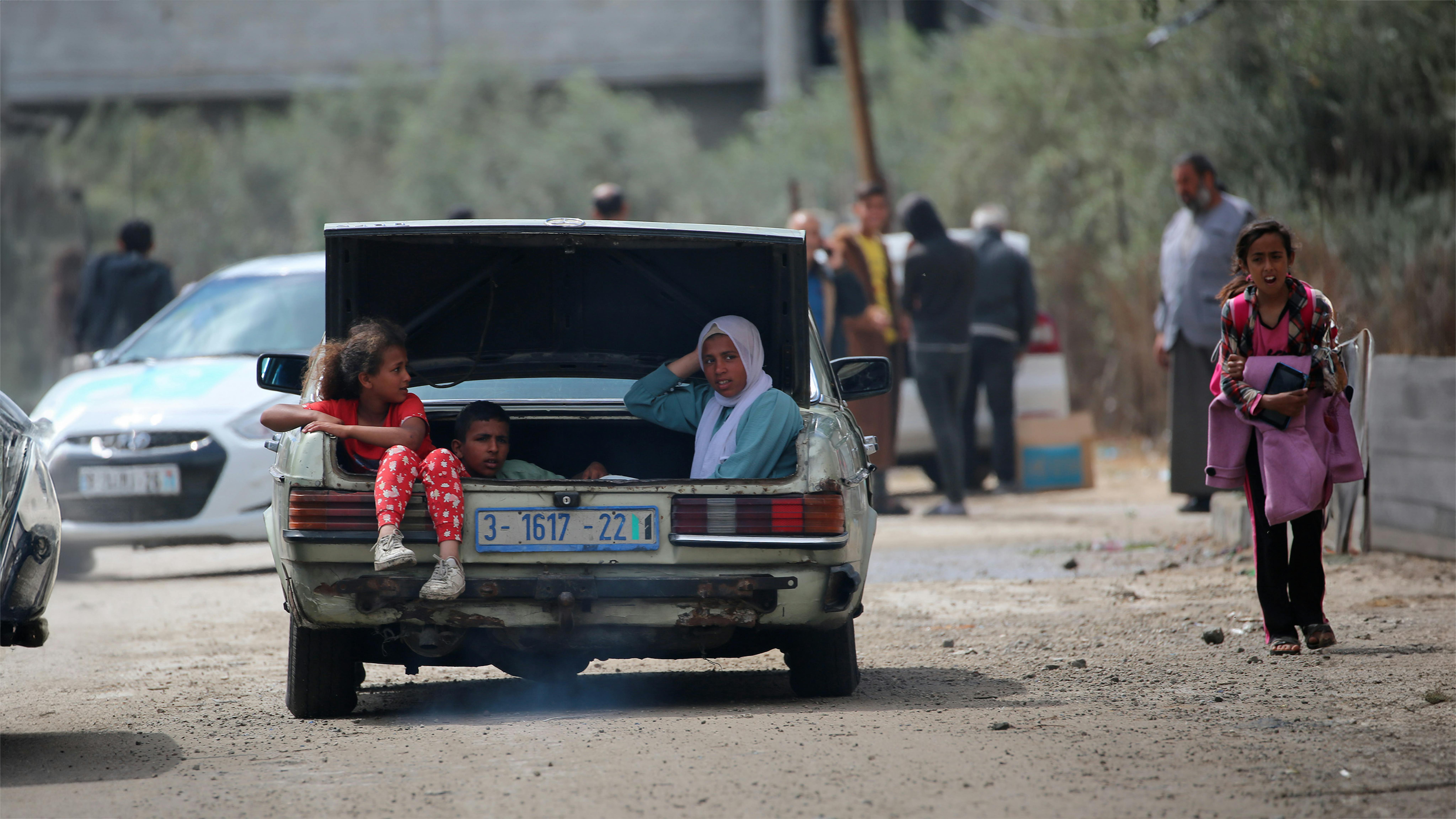 Bambini seduti nel bagagliaio di un'auto durante il loro sfollamento da Rafah, a sud della Striscia di Gaza, a causa dei continui bombardamenti e delle ostilità.