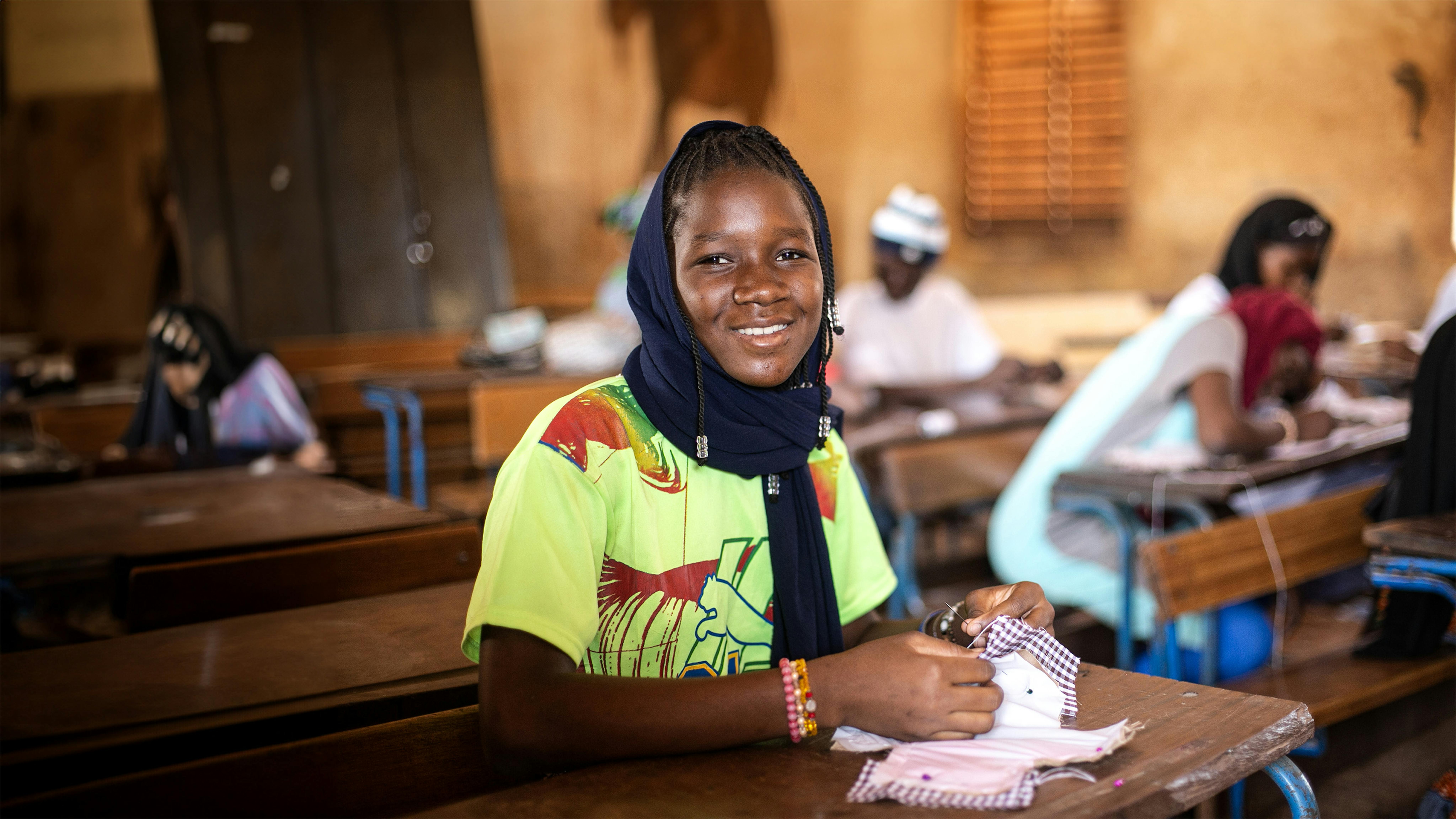 Mali - Oumou Touré, 14 anni, classe 6a elementare, sta cucendo a mano un assorbente.