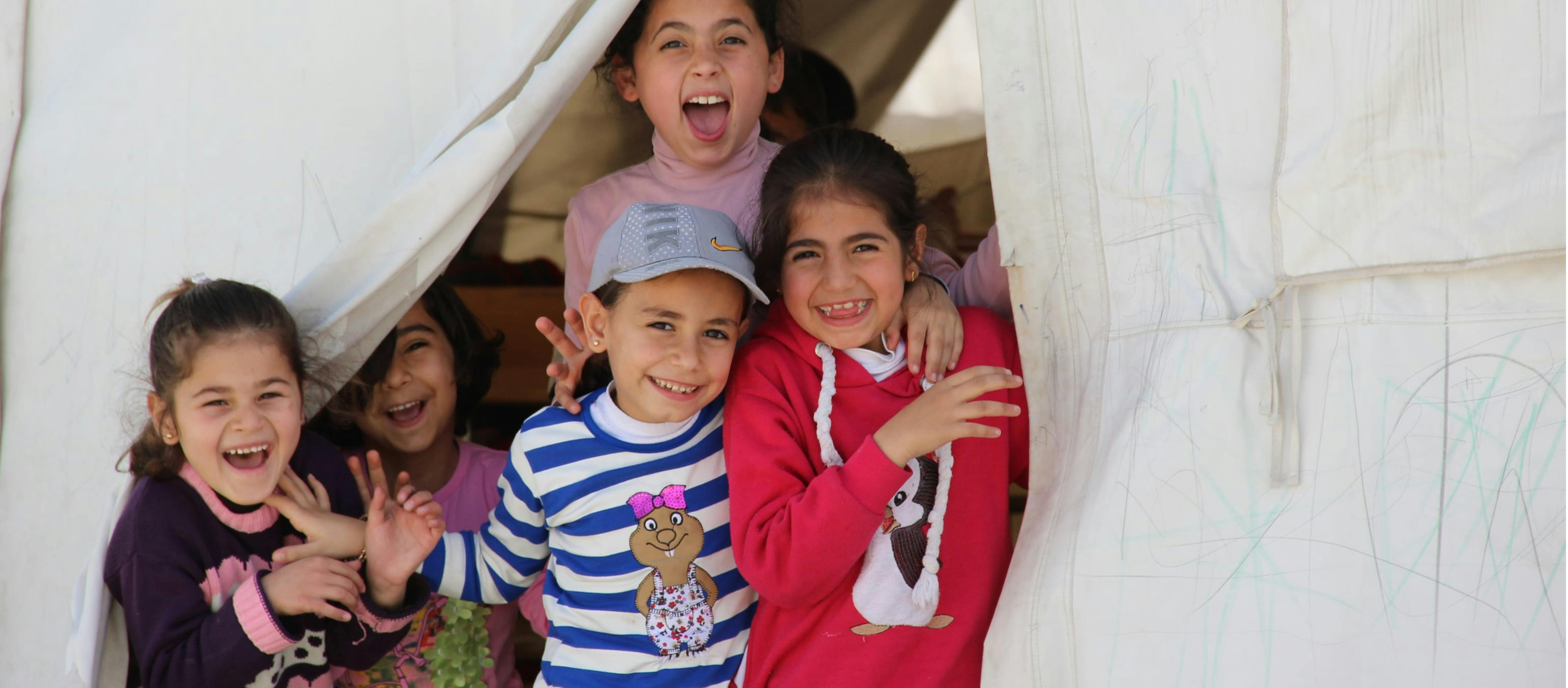 Bambine escono da una tenda/rifugio sorridenti