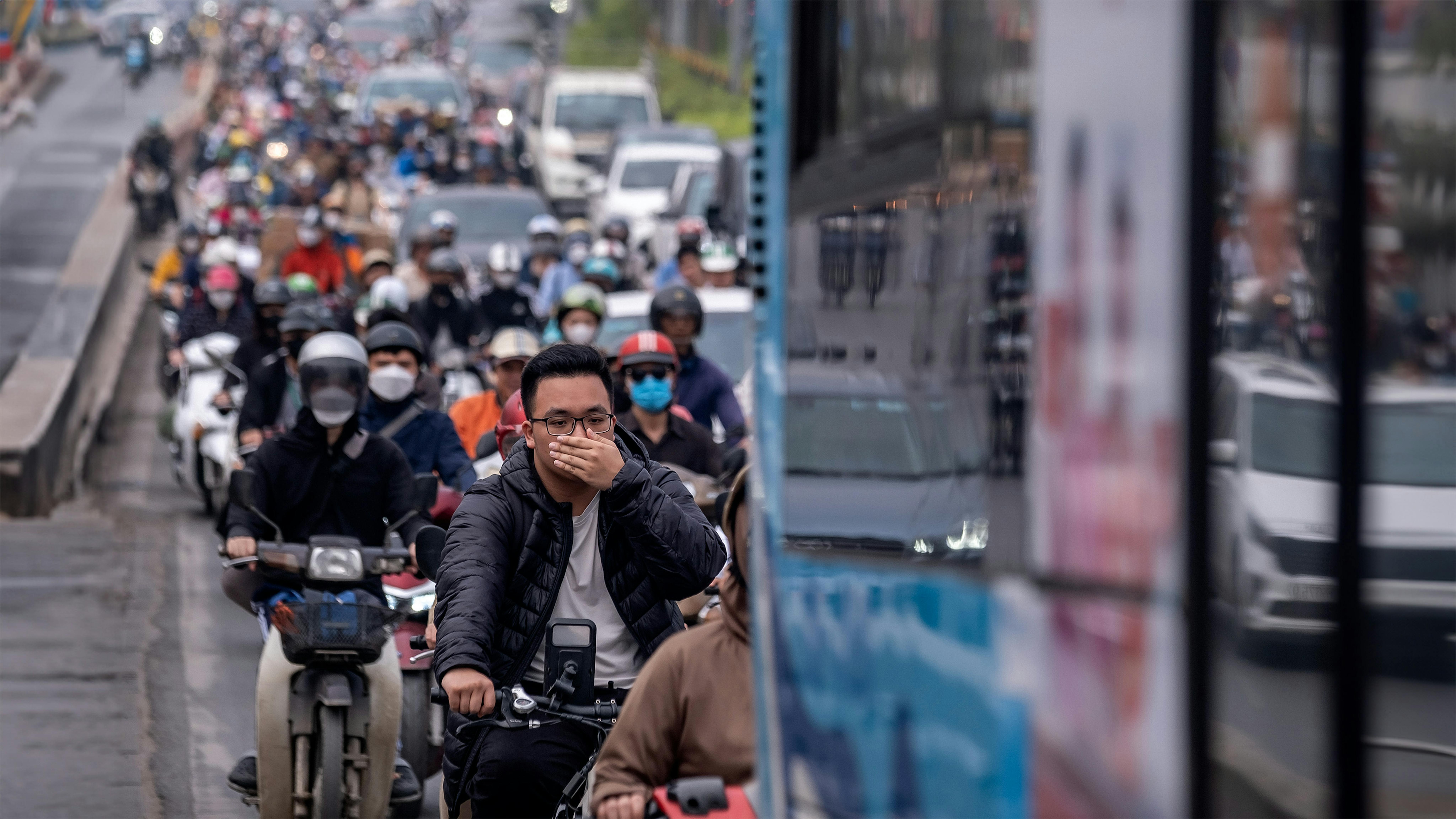 Vietnam: i residenti indossano le mascherine mentre viaggiano in moto durante l'ora di punta mattutina all'incrocio di Nga Tu So.