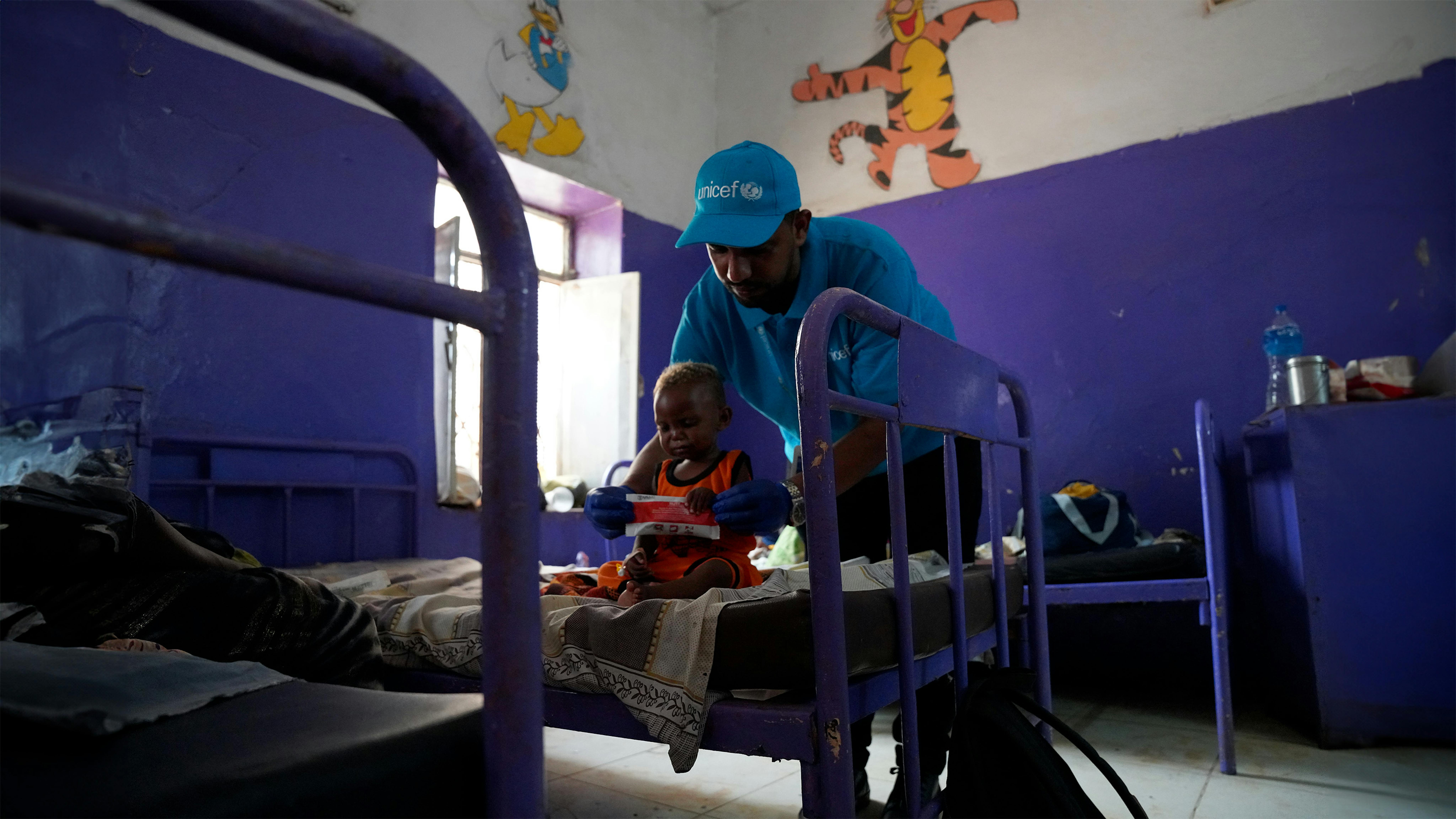 Sudan - L'operatore sanitario e nutrizionale Mohamed Almugtba Khider nutre Mahdi, 16 mesi, con cibo terapeutico pronto all'uso