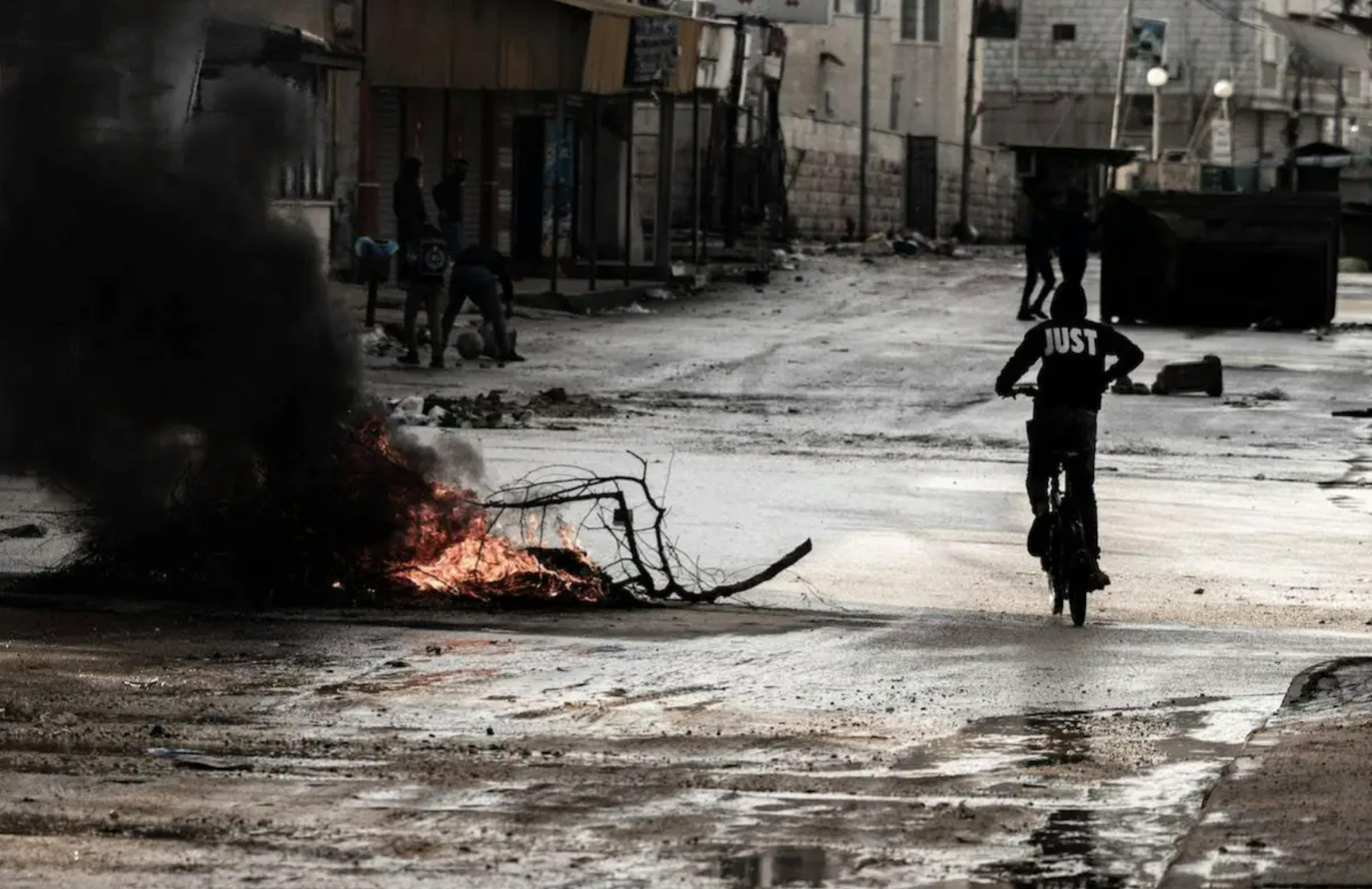 Soldati israeliani si scontrano con palestinesi nel luogo in cui le forze israeliane hanno bombardato 3 case, ucciso 8 palestinesi e feriti altri durante un raid a Jenin, Cisgiordania, il 13 dicembre 2023. [Vincenzo Circosta – Agenzia Anadolu]