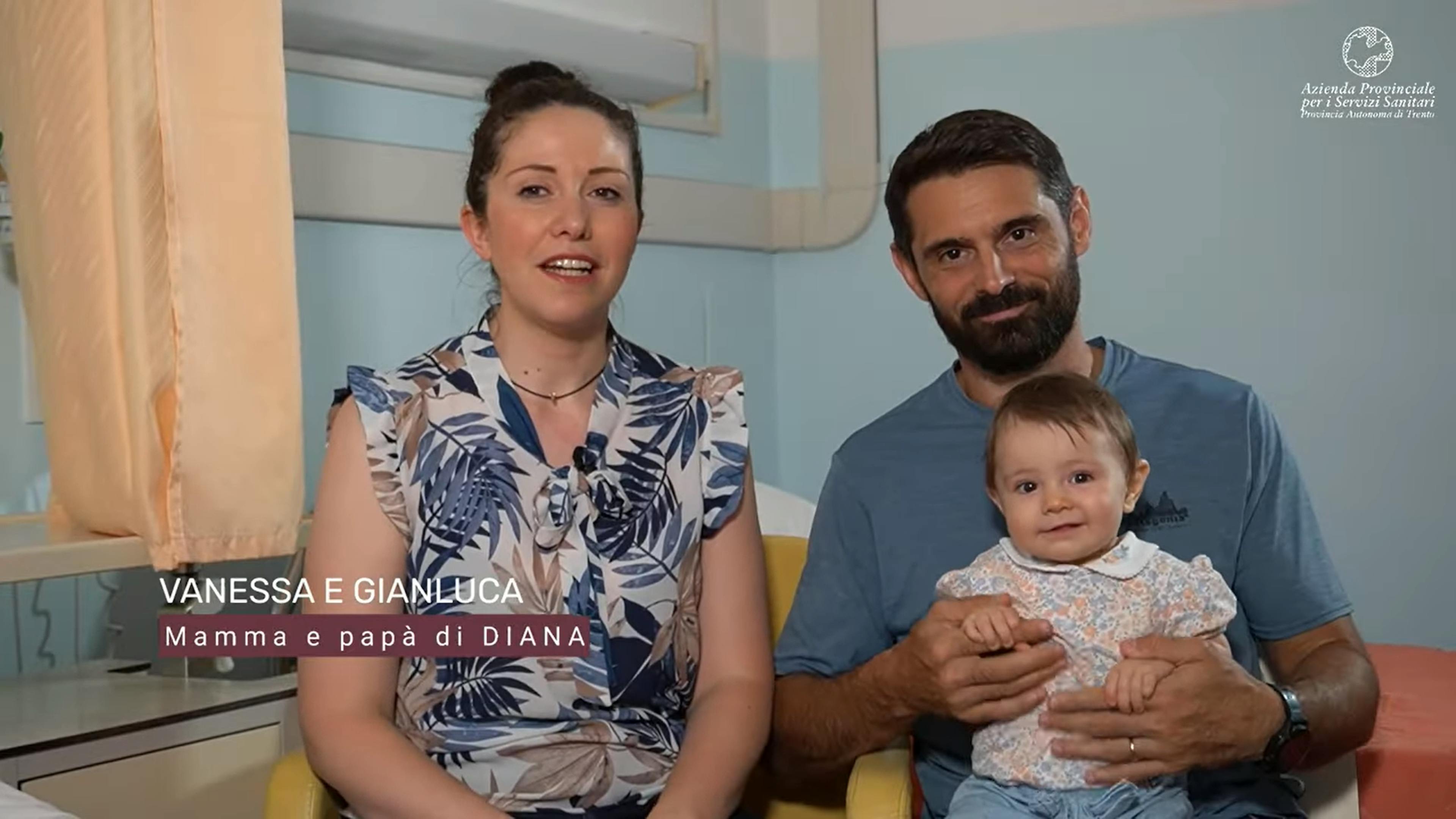 Madre, padre con in braccio una neonata, ambiente ospedale