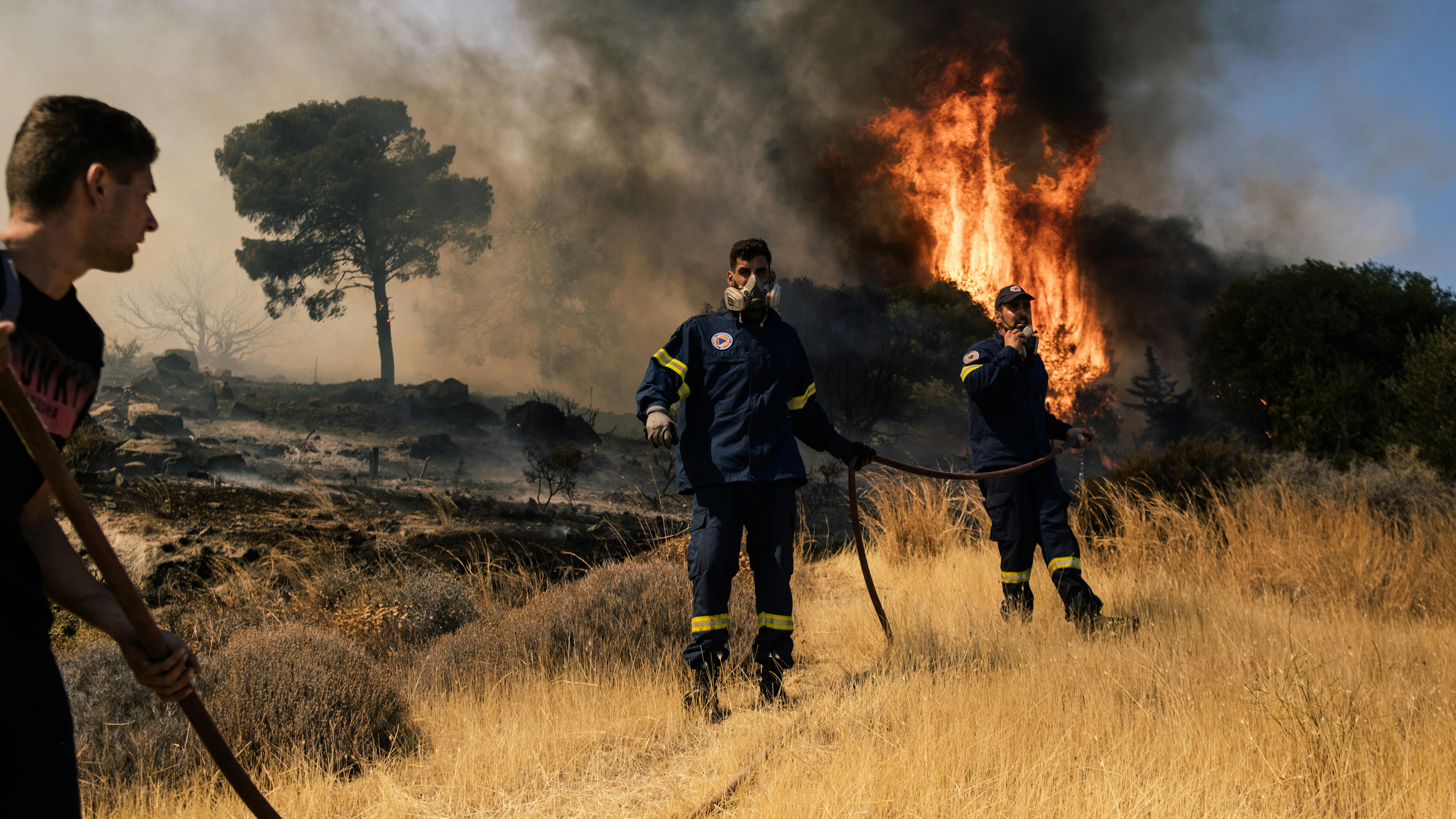 Una squadra di vigili del fuoco cerca di domare lo scoppio di un incendio per evitare che si propaghi nella zona di Plaka, Keratea, 40 km a sud-est di Atene,