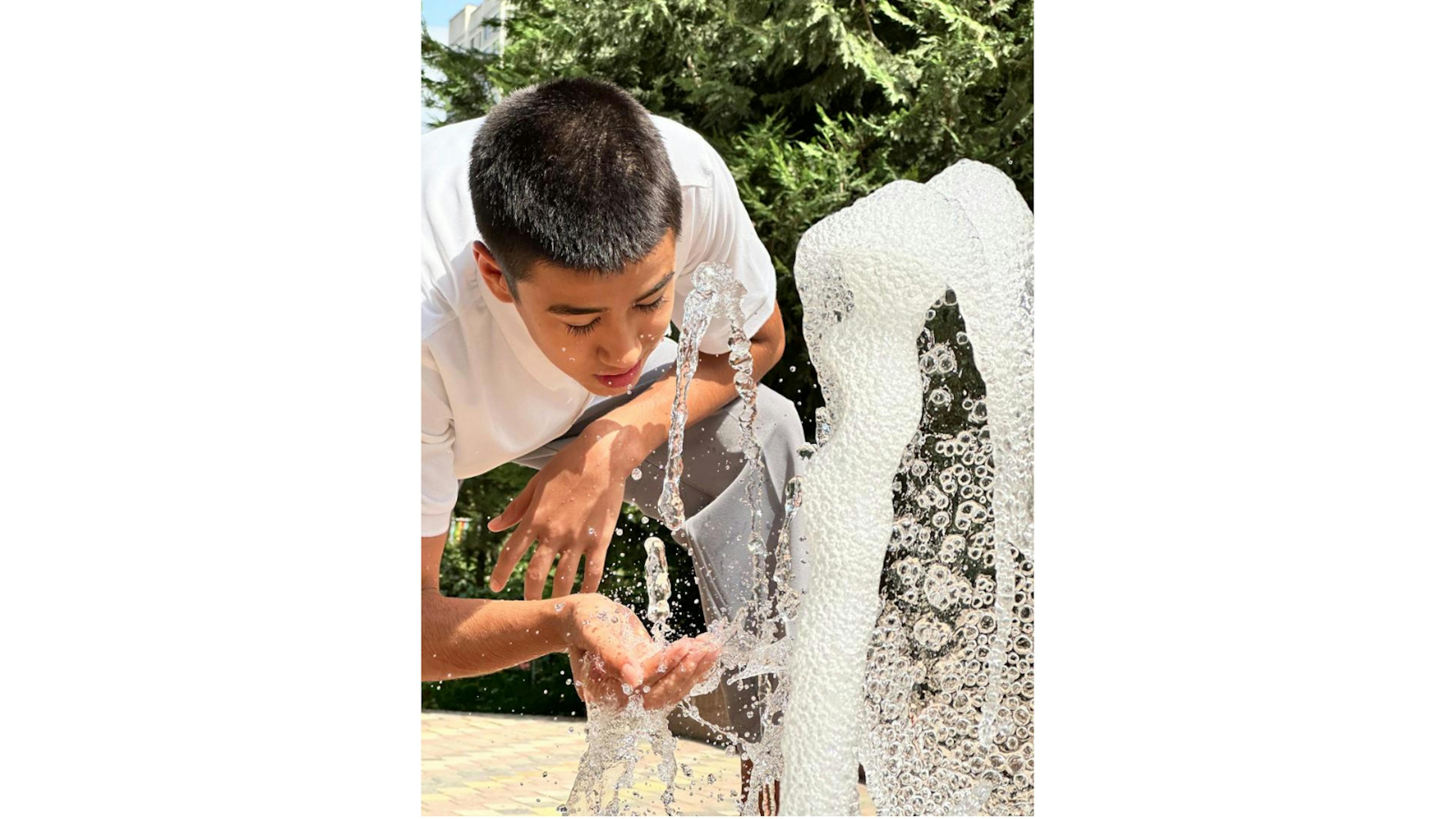 Tajikistan - Khurshed, 13 anni, tornando a casa si rinfresca alla fontana del parco Spartak