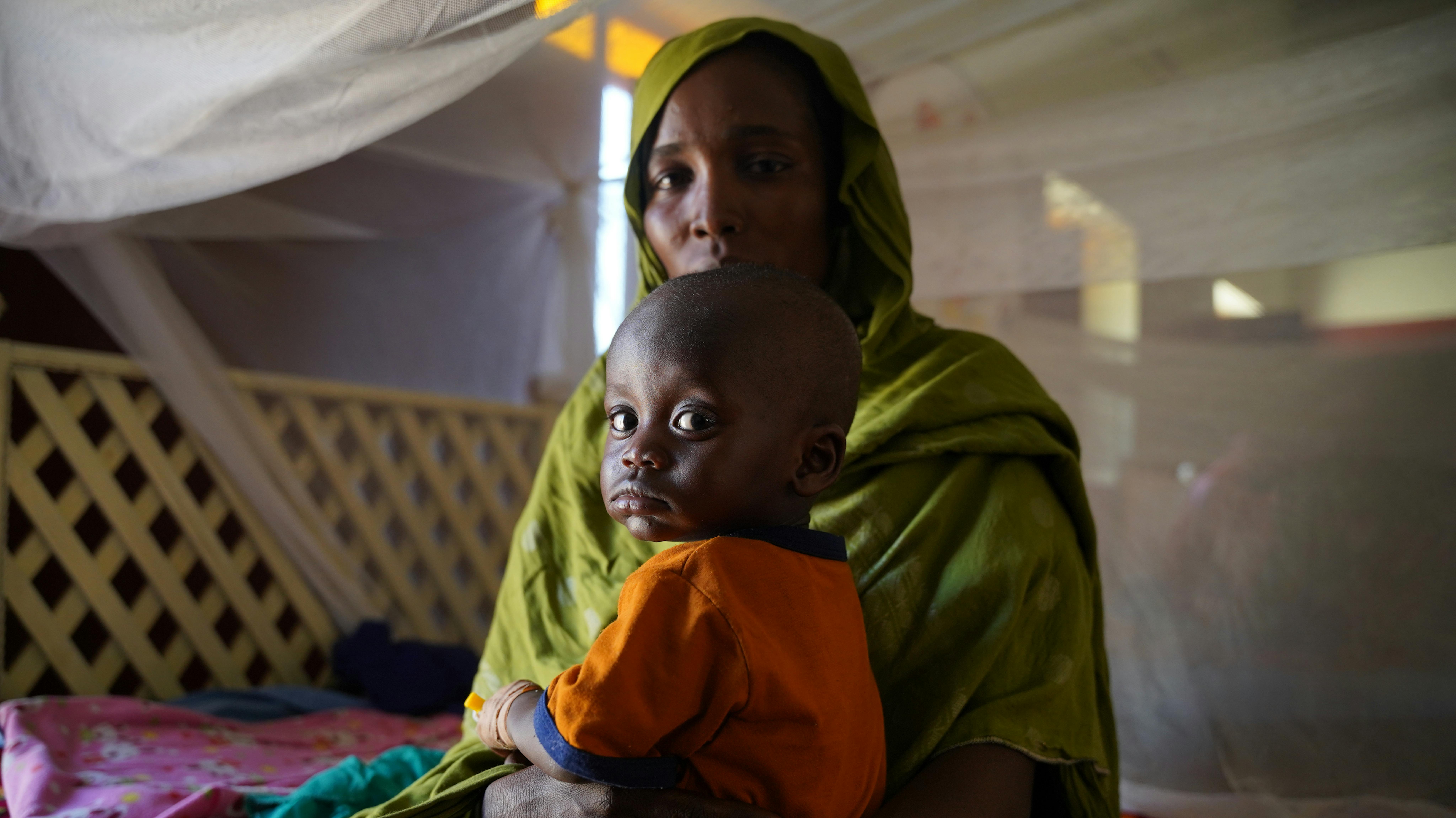 Sudan - Hanona porta il suo bambino Maher in un centro nutrizionale ad Abushok nel Darfur settentrionale per uno screening sanitario.