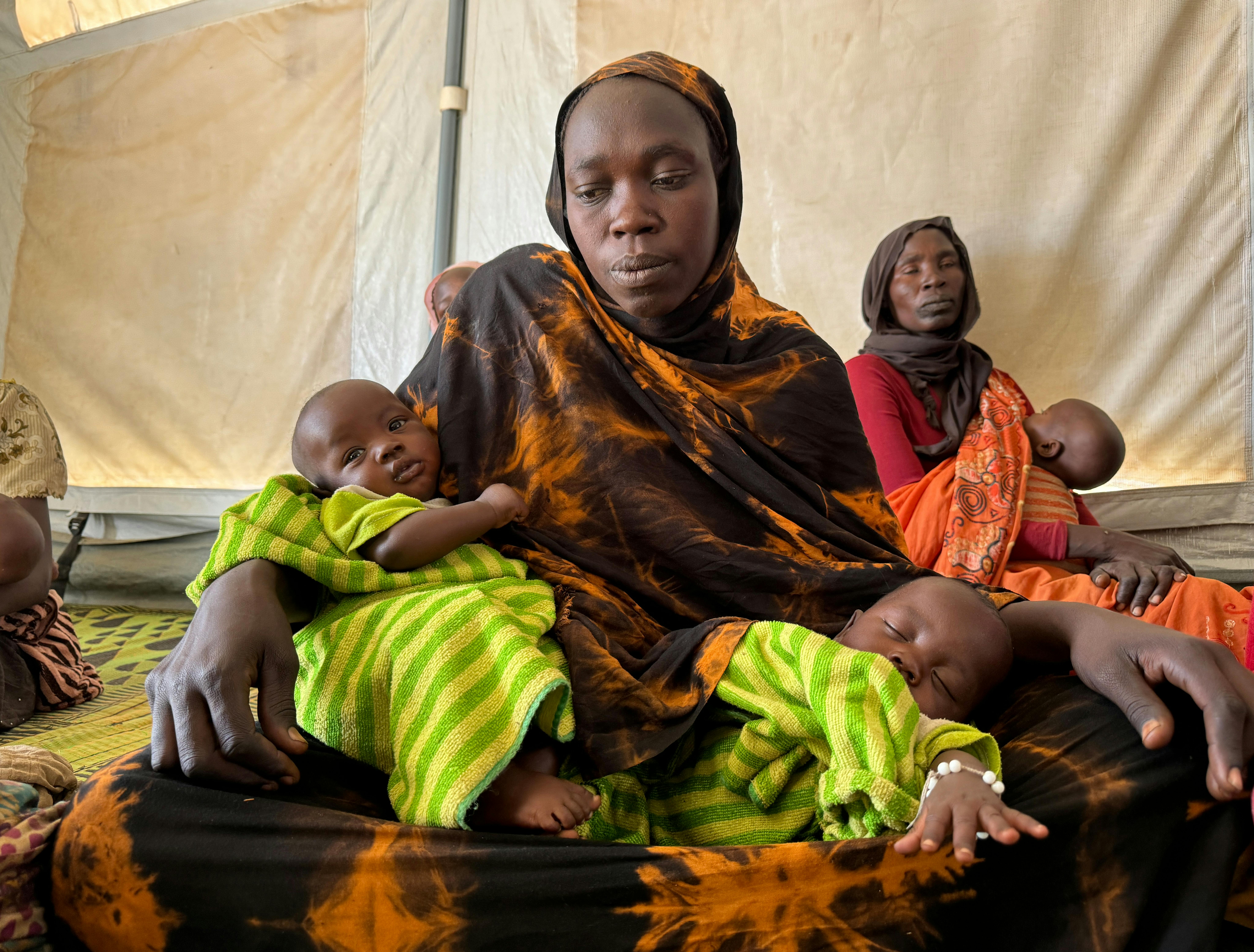 Il 2 febbraio 2024, Djawair Issakh, 25 anni, siede con i suoi gemelli di tre mesi, Hissein e Hassan, in un centro di sensibilizzazione per l'allattamento e la nutrizione supportato dall'UNICEF nel campo profughi di Farchana, nel Ciad orientale. Djawair ha anche due figli più grandi che sono con lei nel campo. Suo marito sta cercando lavori saltuari per aiutare la famiglia a provvedere a se stessa. 