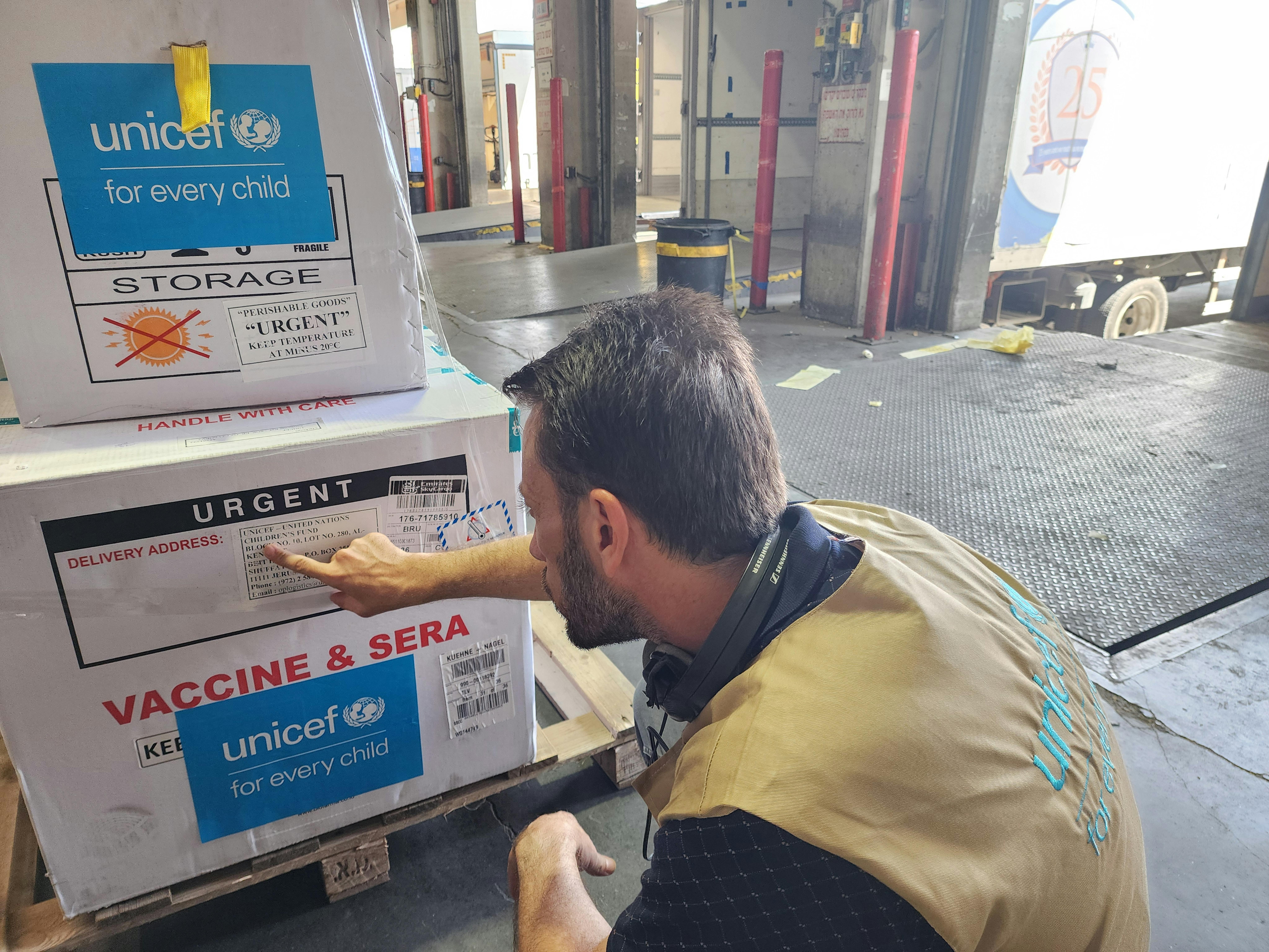 Un membro dello staff UNICEF controlla le forniture di vaccino contro la polio tipo 2 e i contenitori per la catena del freddo arrivati all'aeroporto di Tel Aviv prima del trasporto verso la Striscia di Gaza