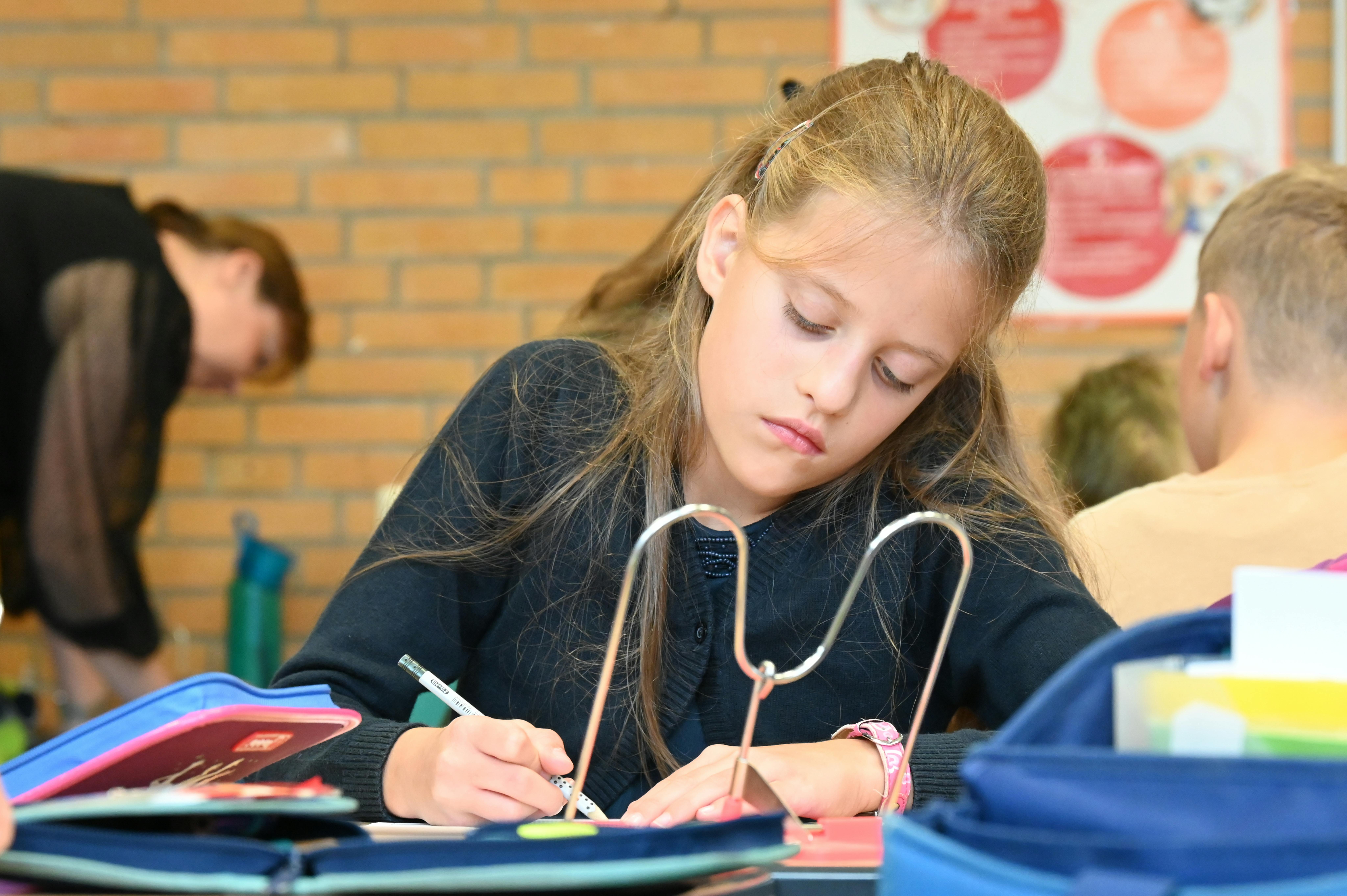 Una bambina annoiata fa i compiti