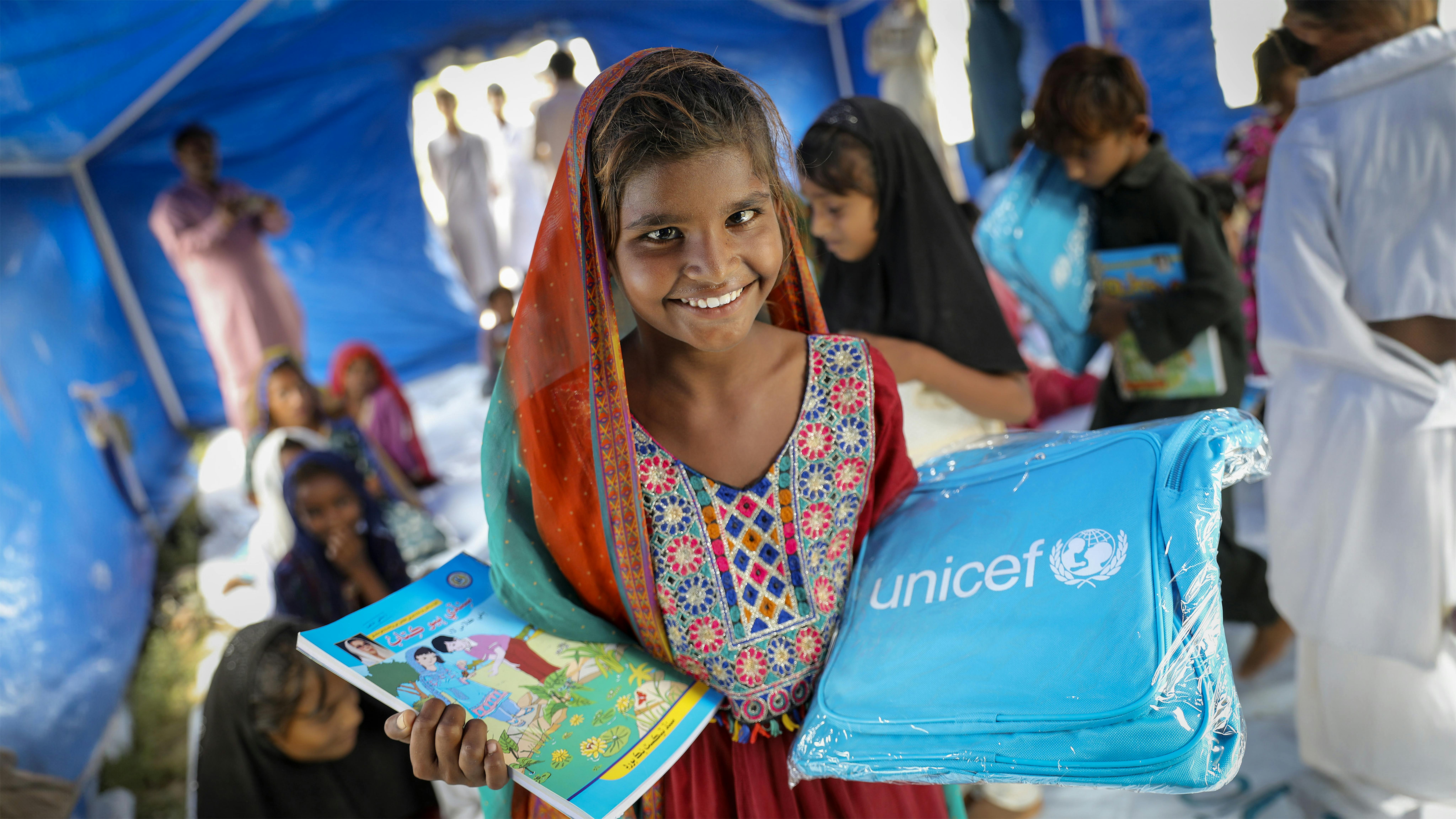 Pakistan - Zareena (8 anni) ha ricevuto la borsa UNICEF nel centro di apprendimento temporaneo supportato dall'UNICEF per i bambini colpiti dall'alluvione nel campo di  Umerkot