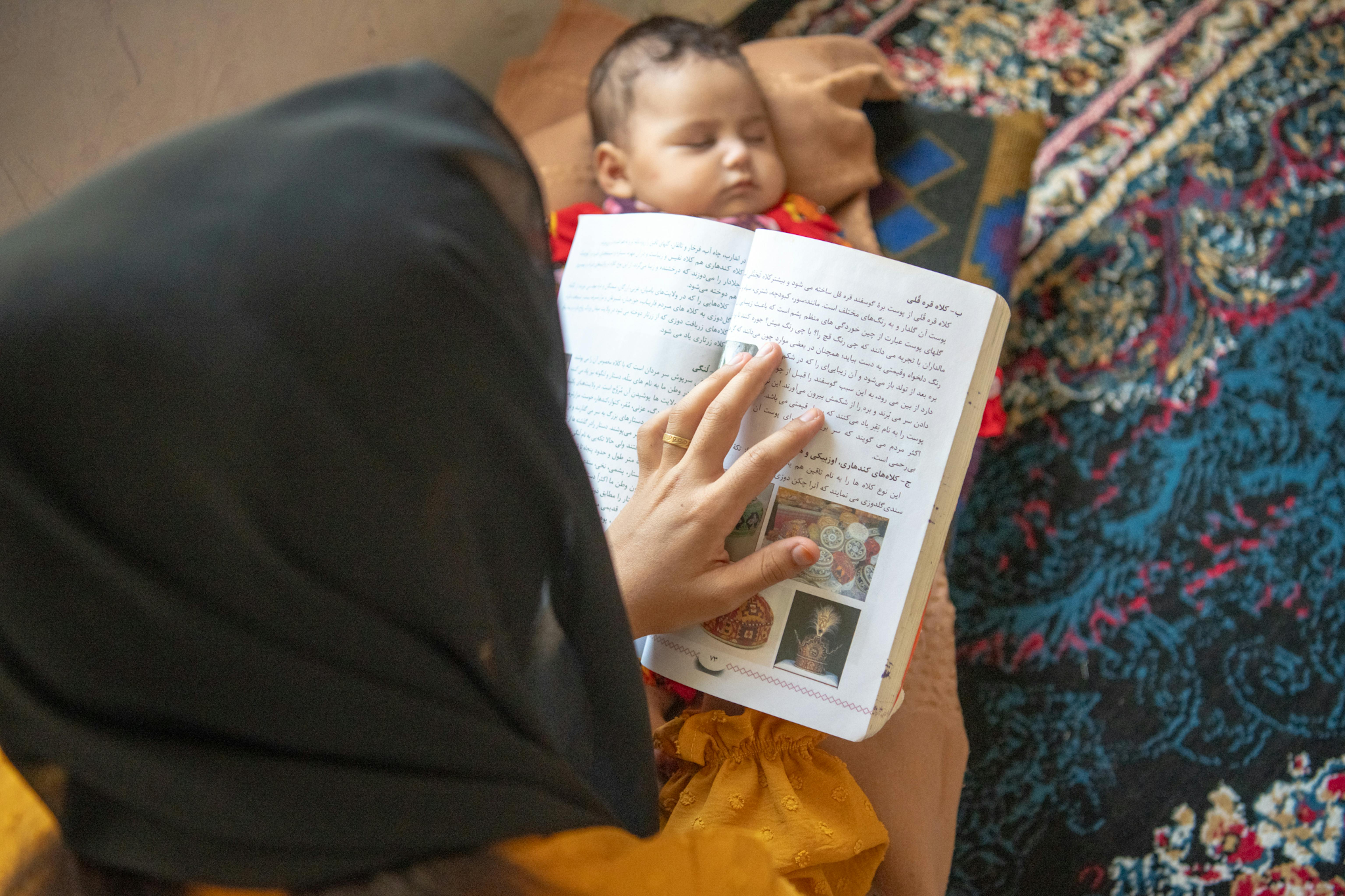 Gulalay* è seduta con la sua bambina di 4 mesi. Aveva 14 anni quando è entrato in vigore il divieto di istruzione secondaria per le ragazze.