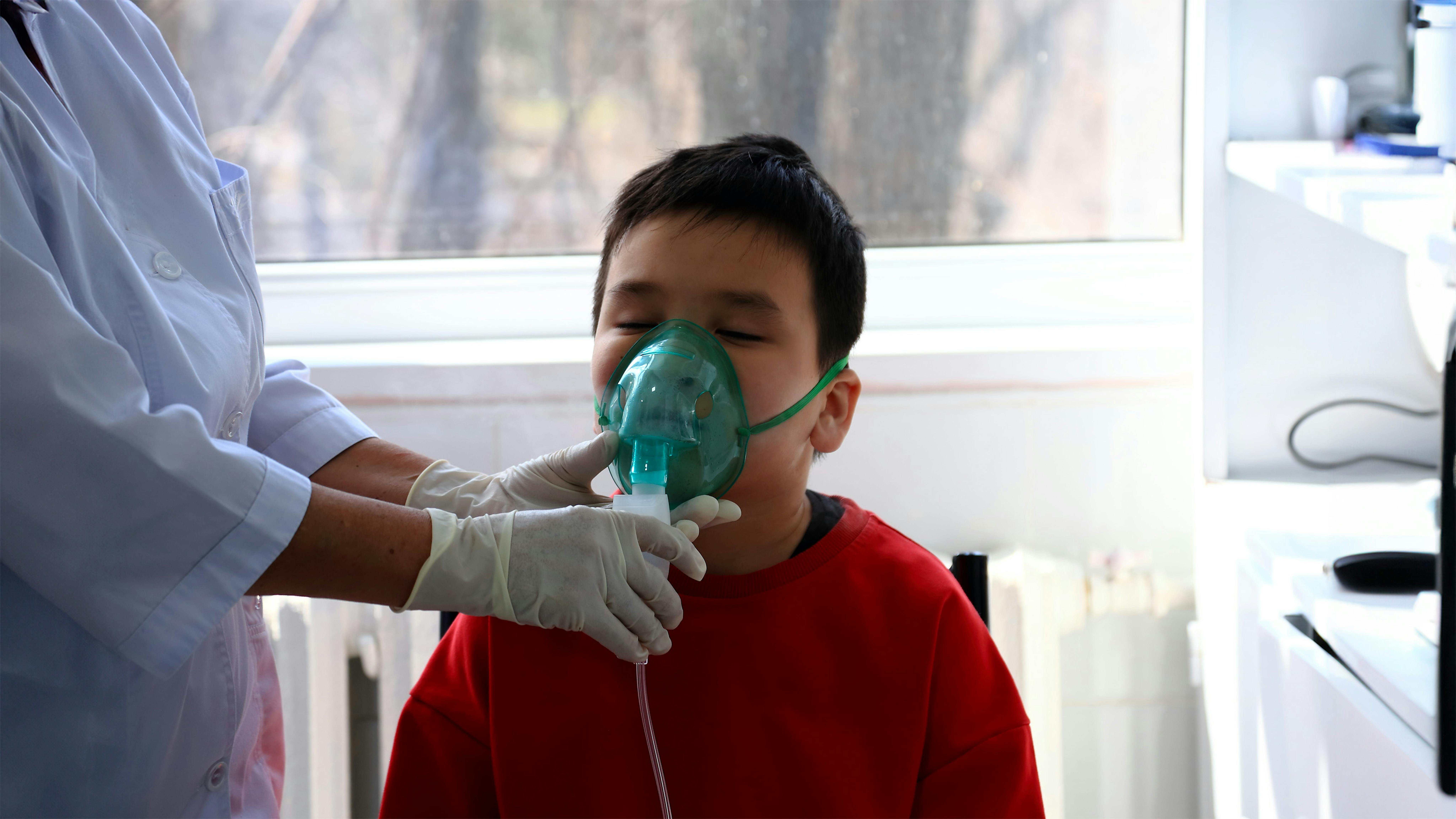 Kyrgyzstan - un bambino nel National Center for Maternal and Child Health di Bishkek respira attraverso una mascherina con un'infermiera accanto a lui. Ci sono molti bambini piccoli in ospedale.
