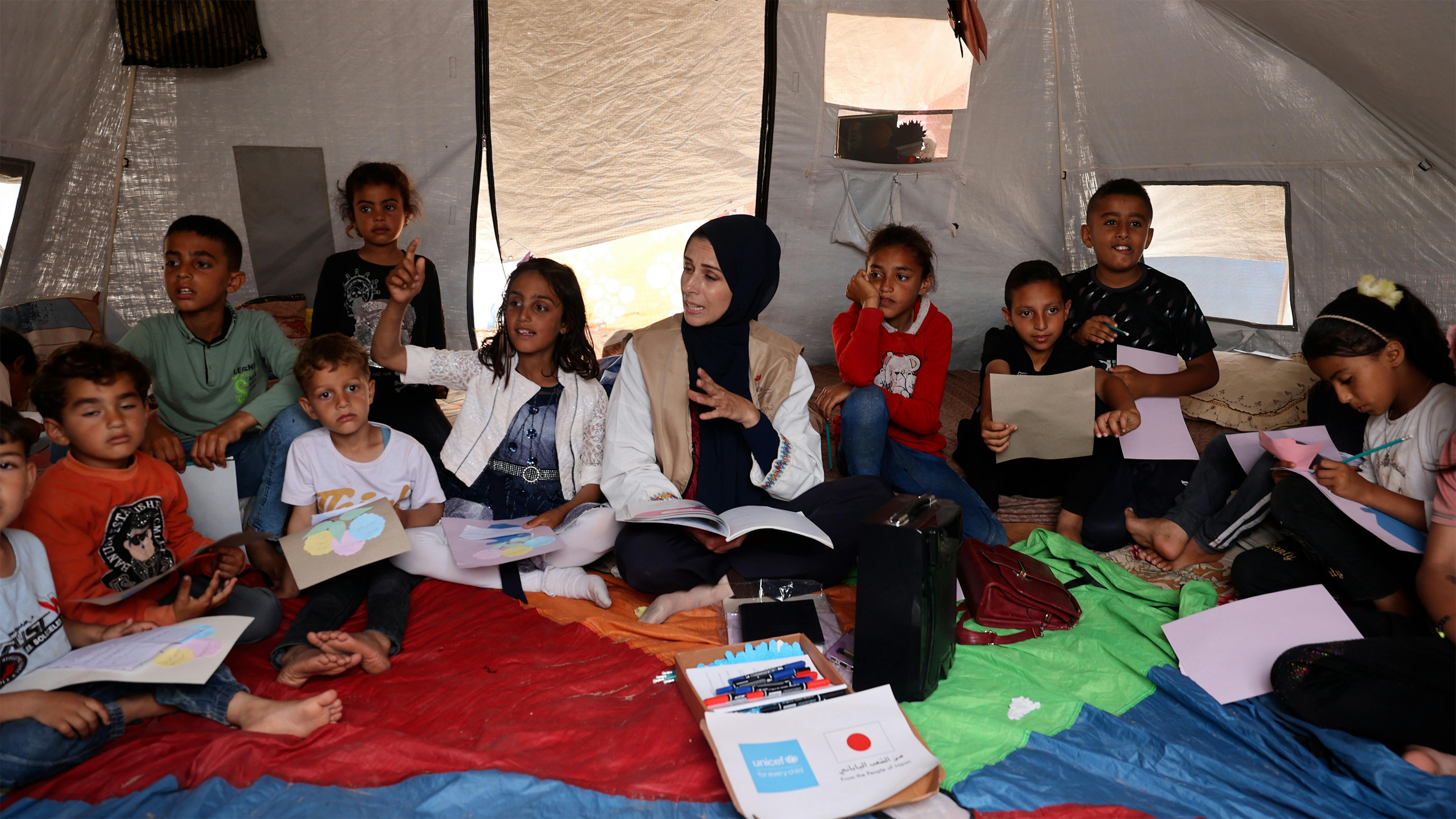 Un gruppo di bambini partecipa a una sessione su come ricordare i propri nomi e quelli dei genitori nella Striscia di Gaza meridionale.