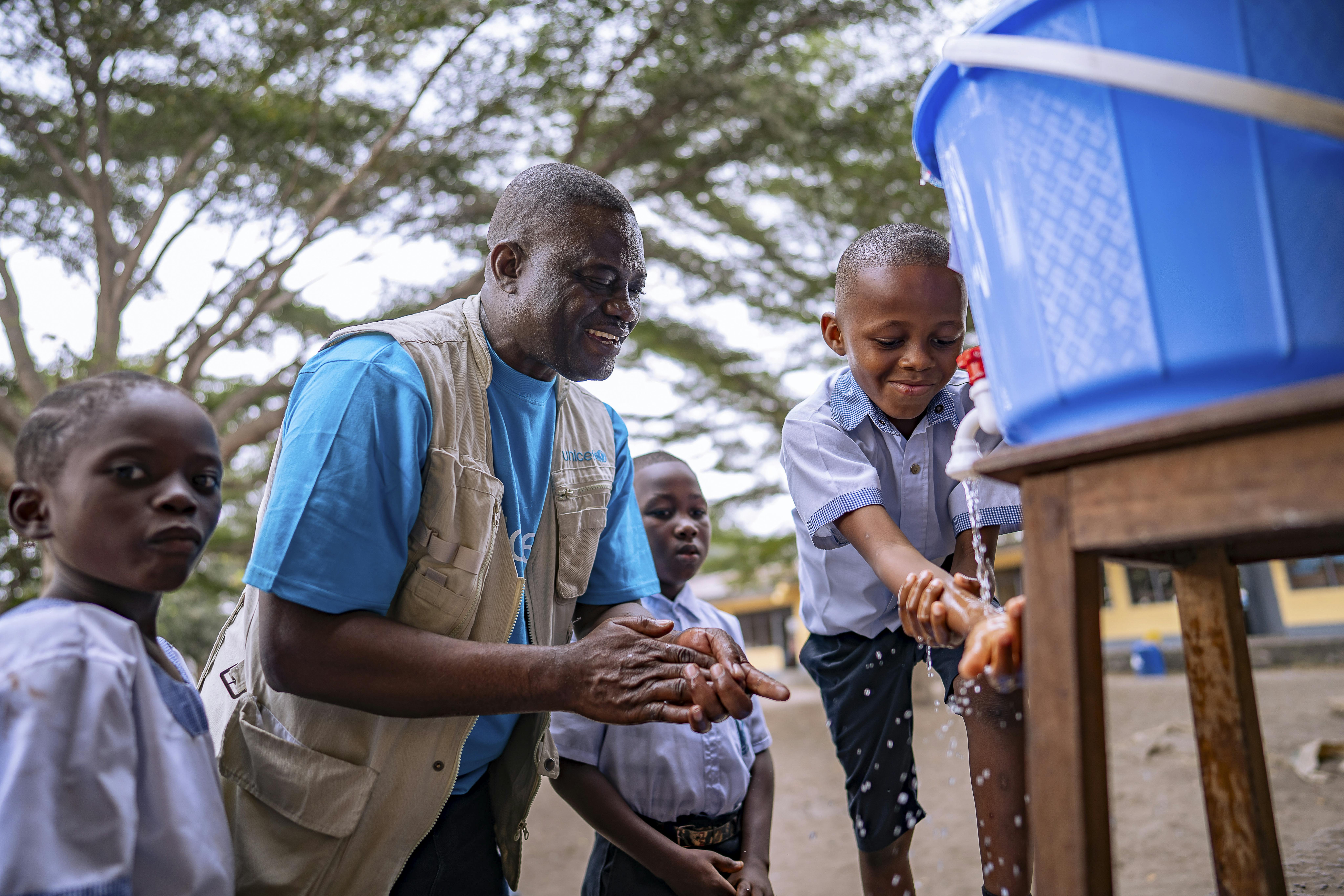 Nico Luketo, referente istruzione per l'UNICEF, mostra agli alunni della scuola primaria Marie Madeleine come lavarsi le mani per proteggersi dal virus Mpox a Kinshasa, Repubblica Democratica del Congo, 2 settembre 2024.