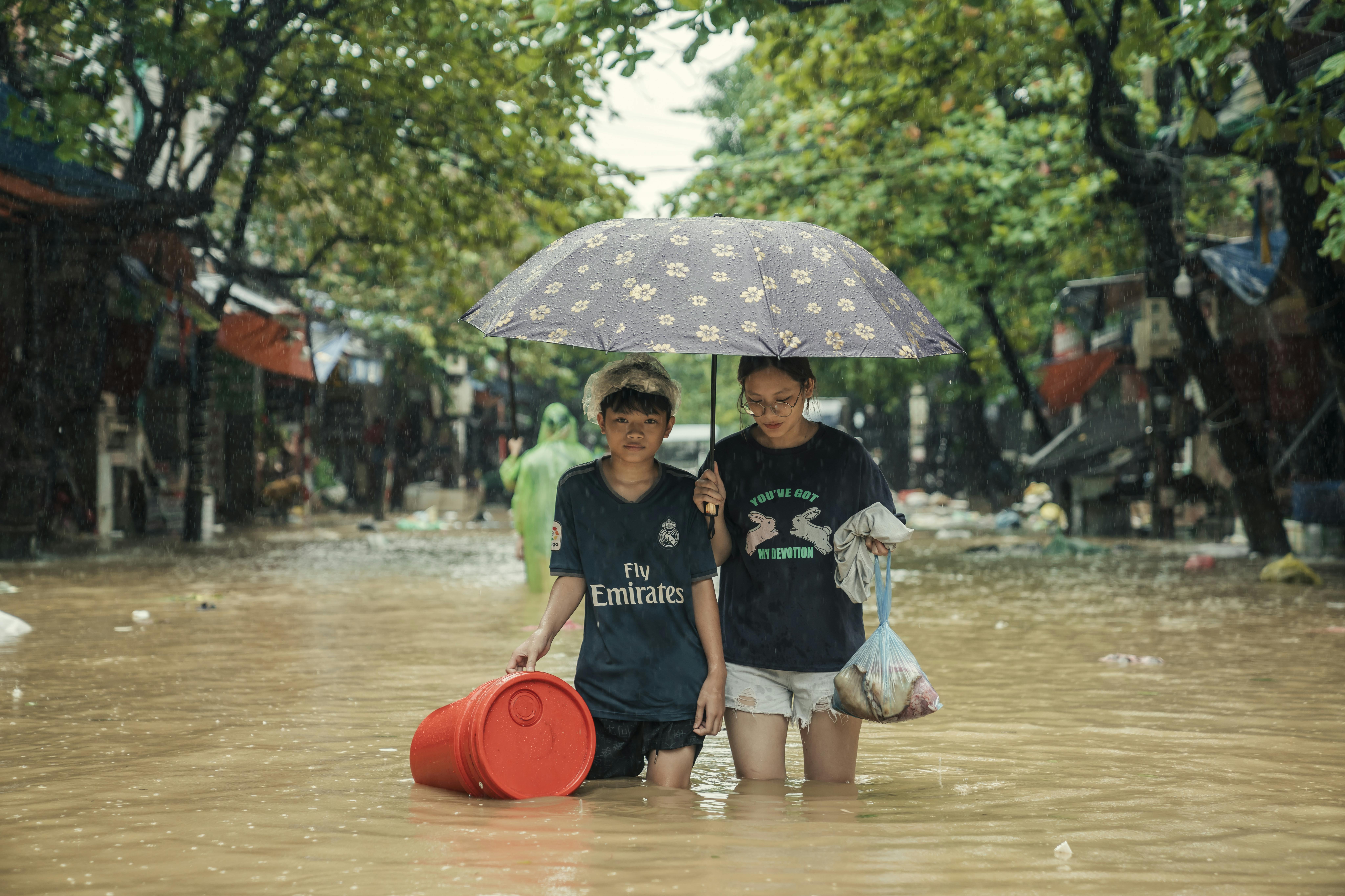 Una famiglia colpita dal tifone Yagi, in Vietnam, prova a portare con sè alcuni averi durante l'avacuazione