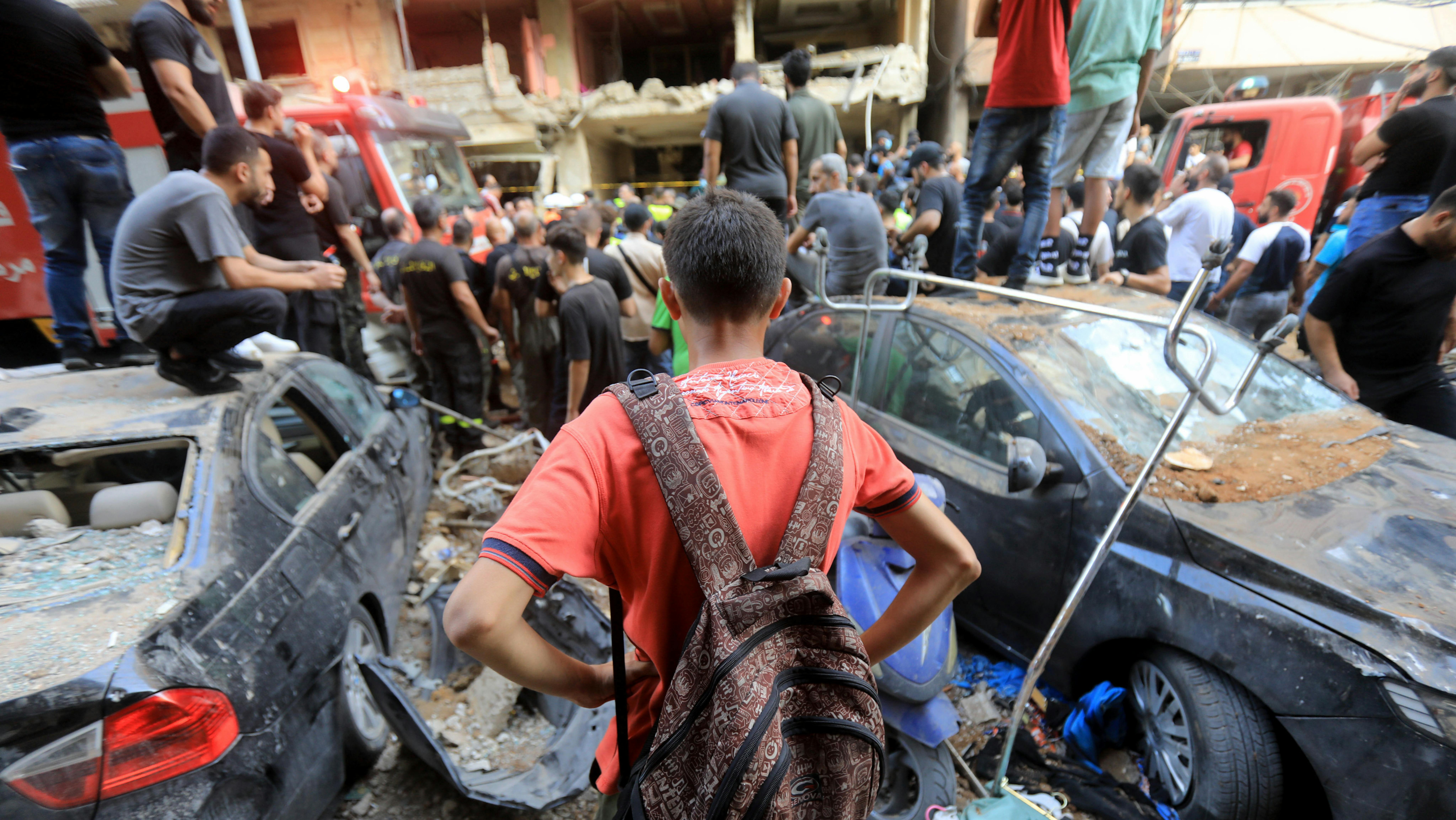 Libano - Un bambino osserva le persone che cercano di rimuovere le macerie da un sito distrutto nella periferia meridionale di Beirut