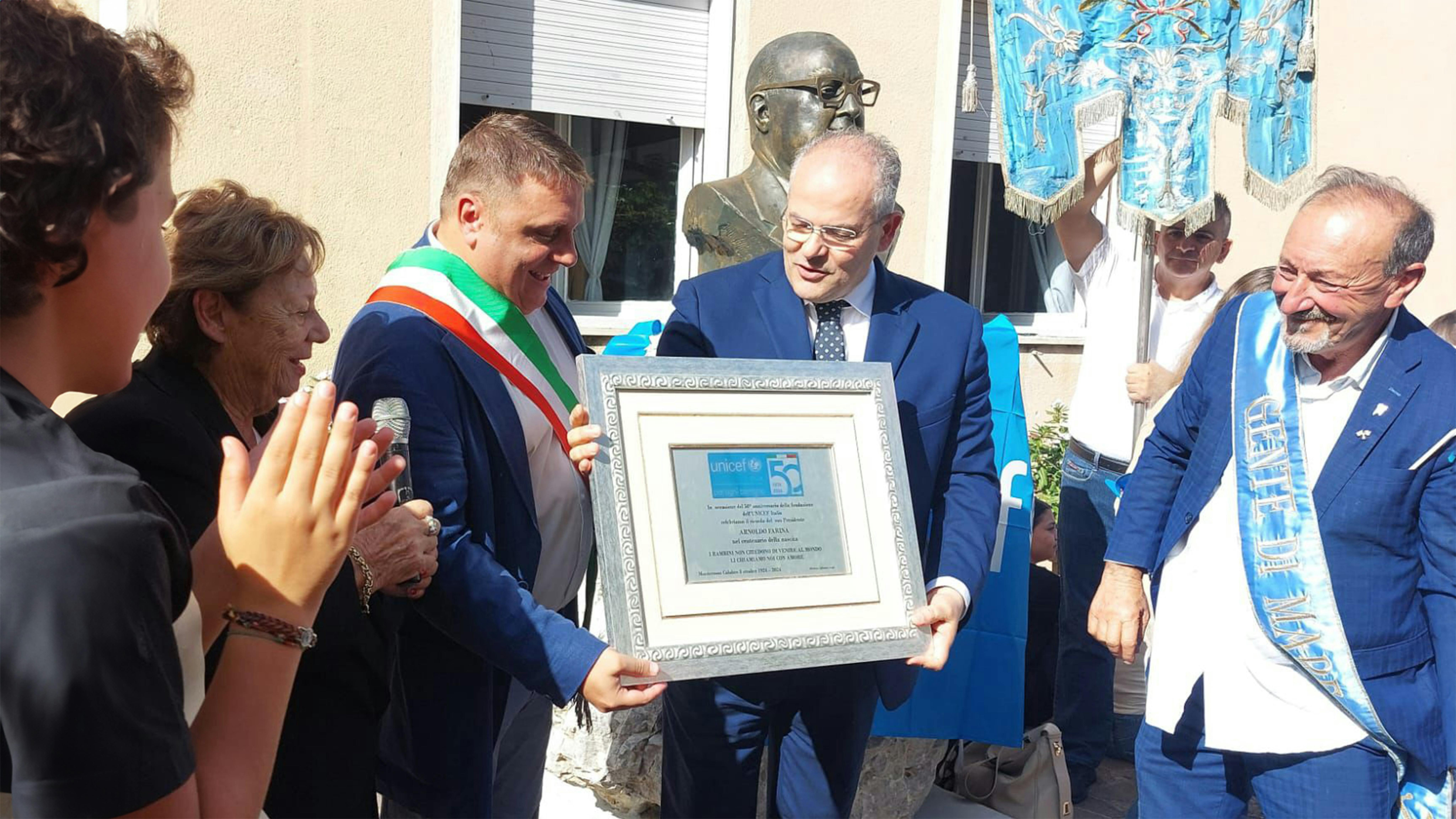 Il Presidente dell'UNICEF Italia Carmela Pace, il Sindaco di Monterosso Calabro Antonio Giacomo Lampasi e l'Ambasciatore UNICEF Michele Affidato con la targa commemorativa esidente dell'UNICEF Italia