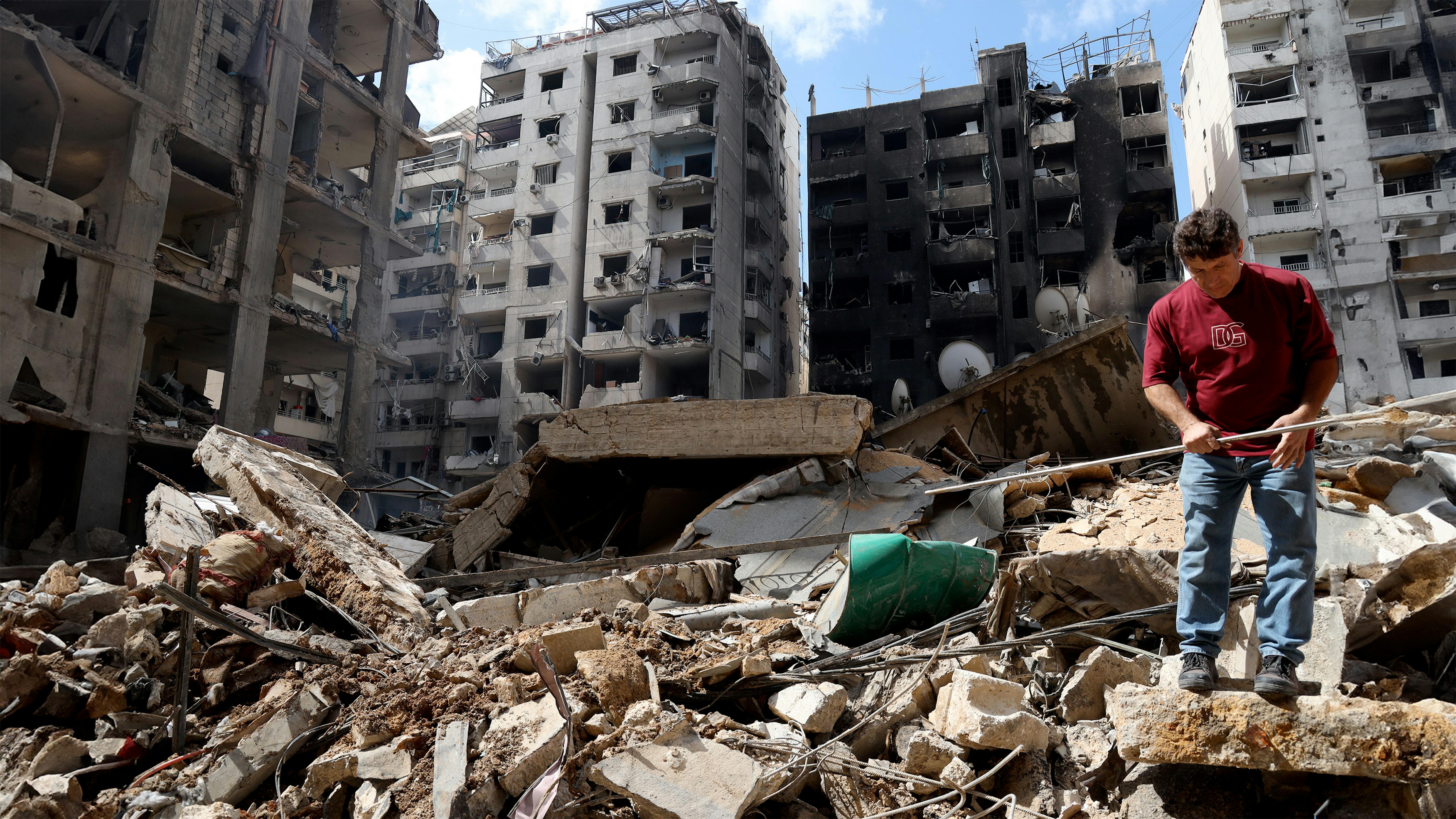 Libano - alcune persone tra le macerie degli edifici rasi al suolo dagli attacchi aerei che hanno preso di mira il quartiere di Saint Therese nella periferia sud di Beirut. Foto Ramzi Haidar / Dar al-Mussawir