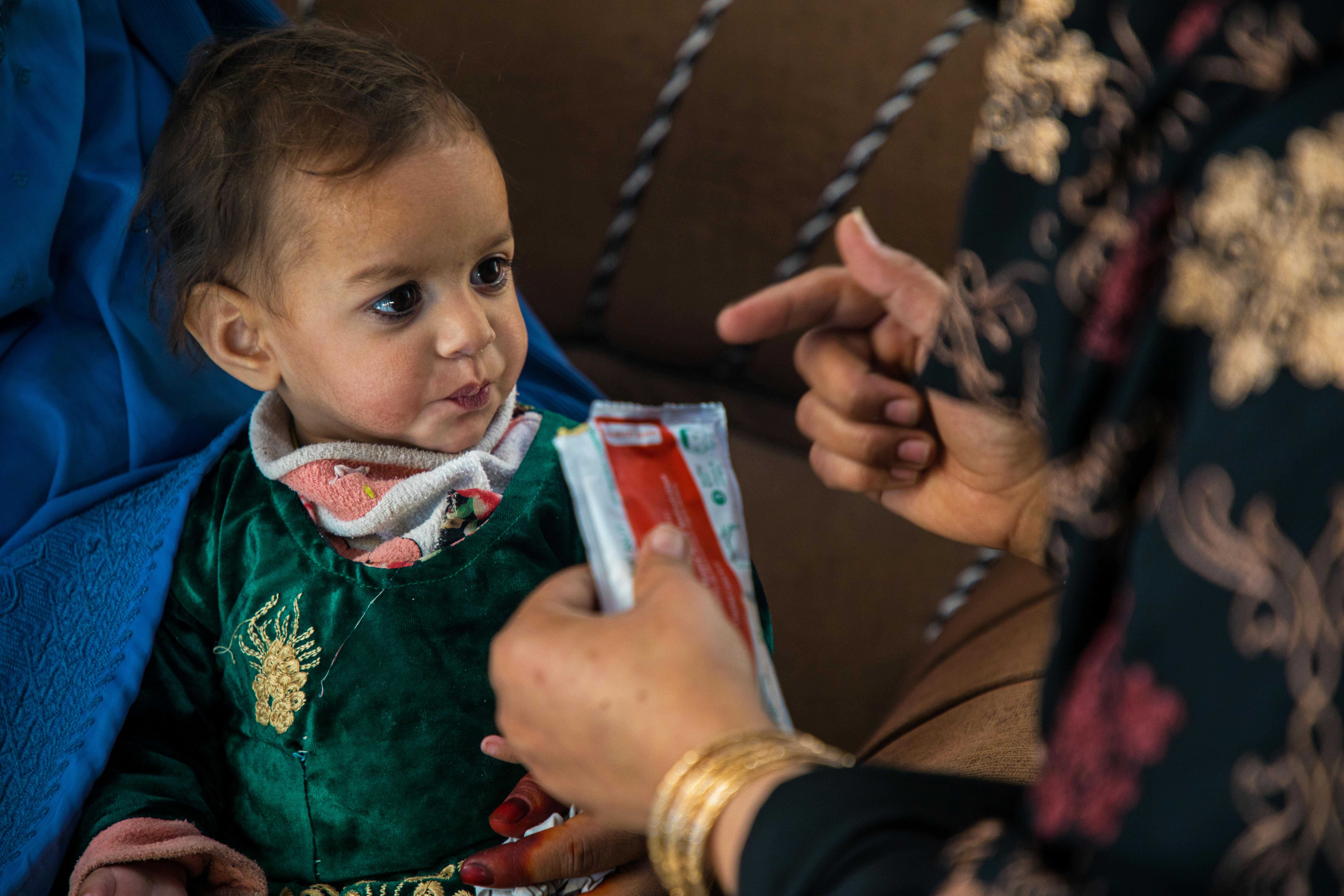 Afghanistan: Narges Ehsan, consulente per la nutrizione presso la clinica Nahri Shahi sta alimentando con il RUFT questa bambina malnutrita