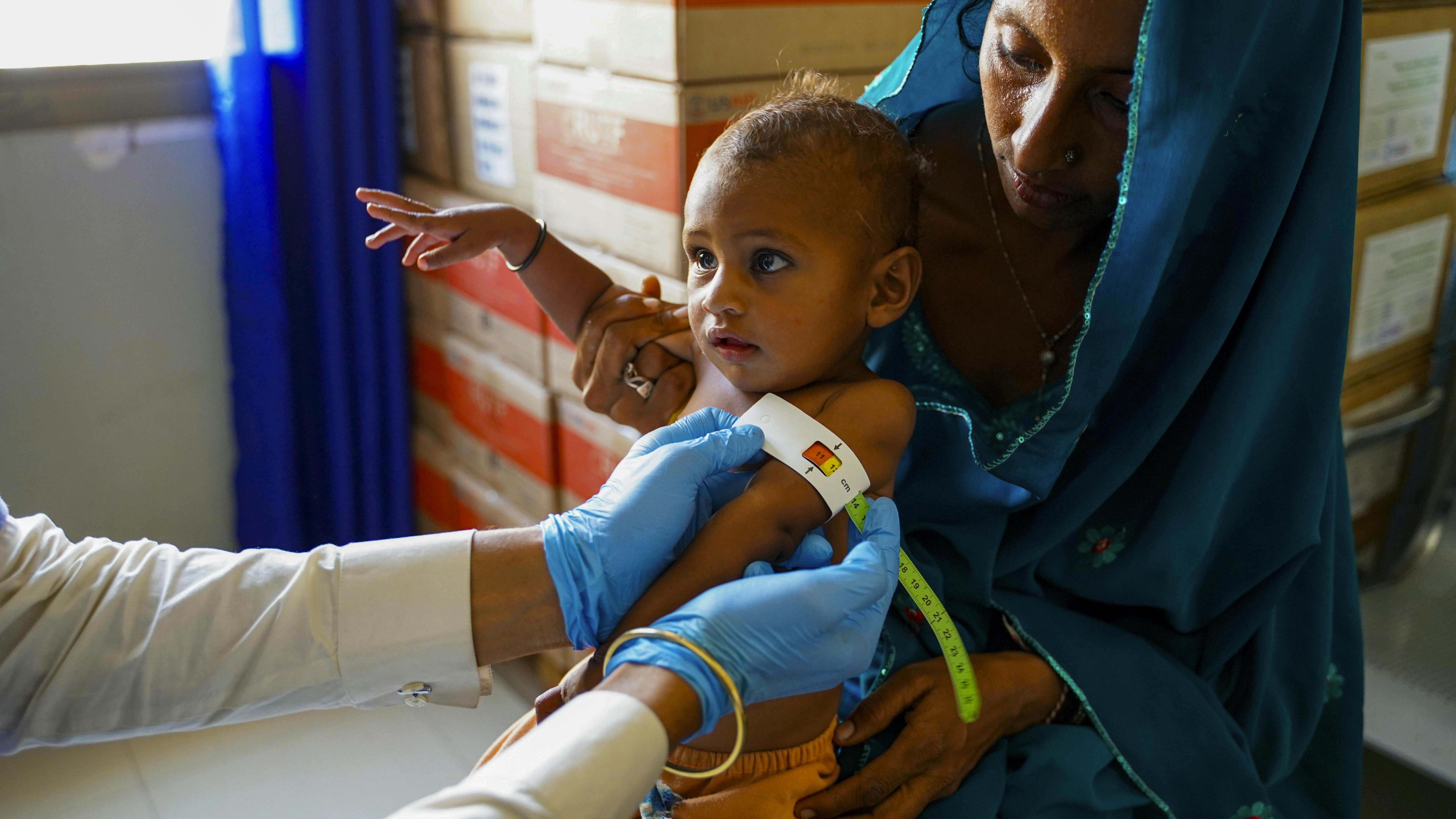 Pakistan: un operatore sanitario utilizza il braccialetto MUAC su un bambino per individuare il livello di malnutrizione. Ci troviamo nella clinica sanitaria sostenuta dall'UNICEF nel villaggio di Jio Kaloi, Mirpurkhas, Sindh.