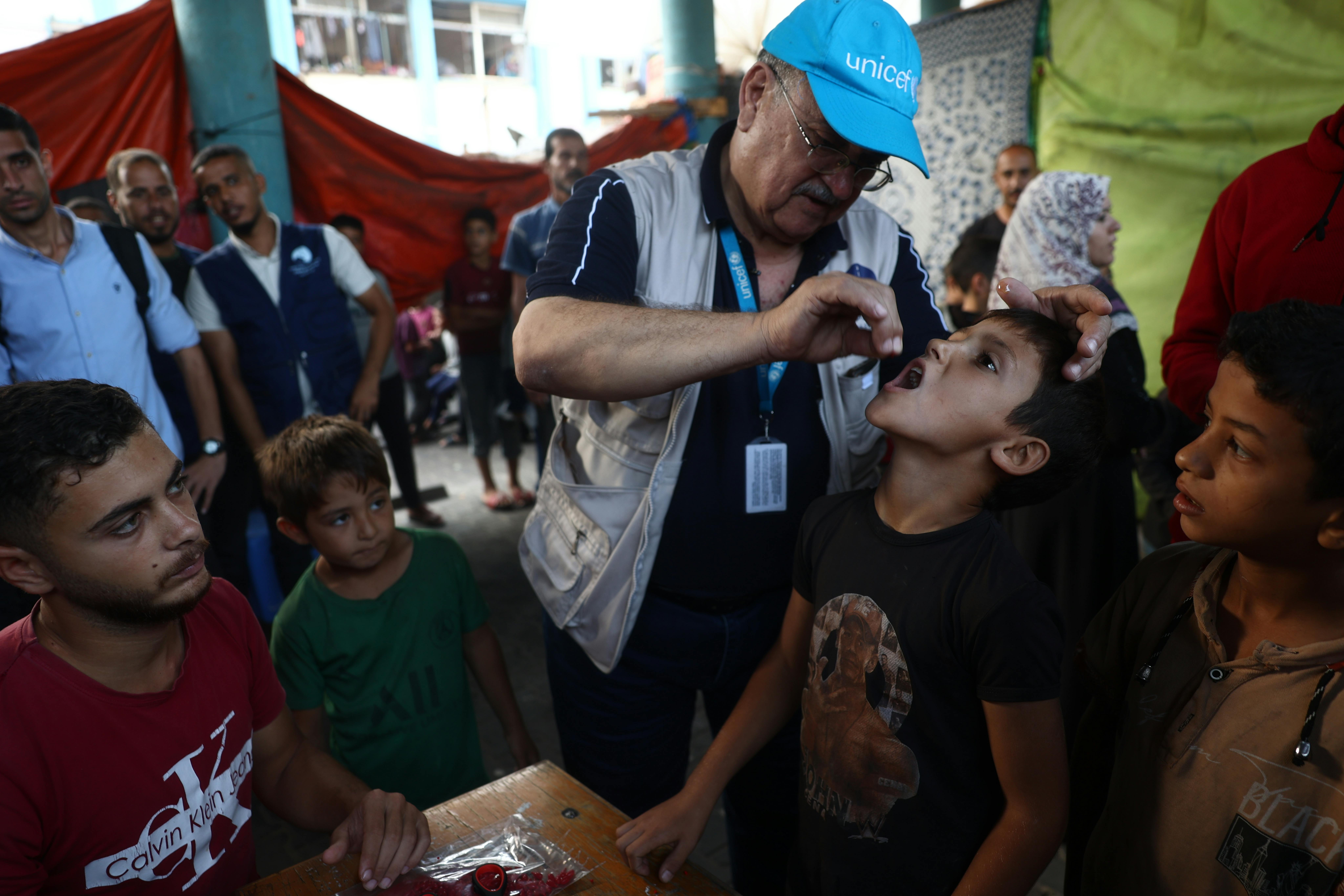 14 ottobre 2024 – A un bambino viene somministrata una dose di vitamina A dopo aver ricevuto la seconda dose del vaccino antipolio presso un centro vaccinale designato nella scuola dell'UNRWA a Deir al-Balah, nel centro della Striscia di Gaza.