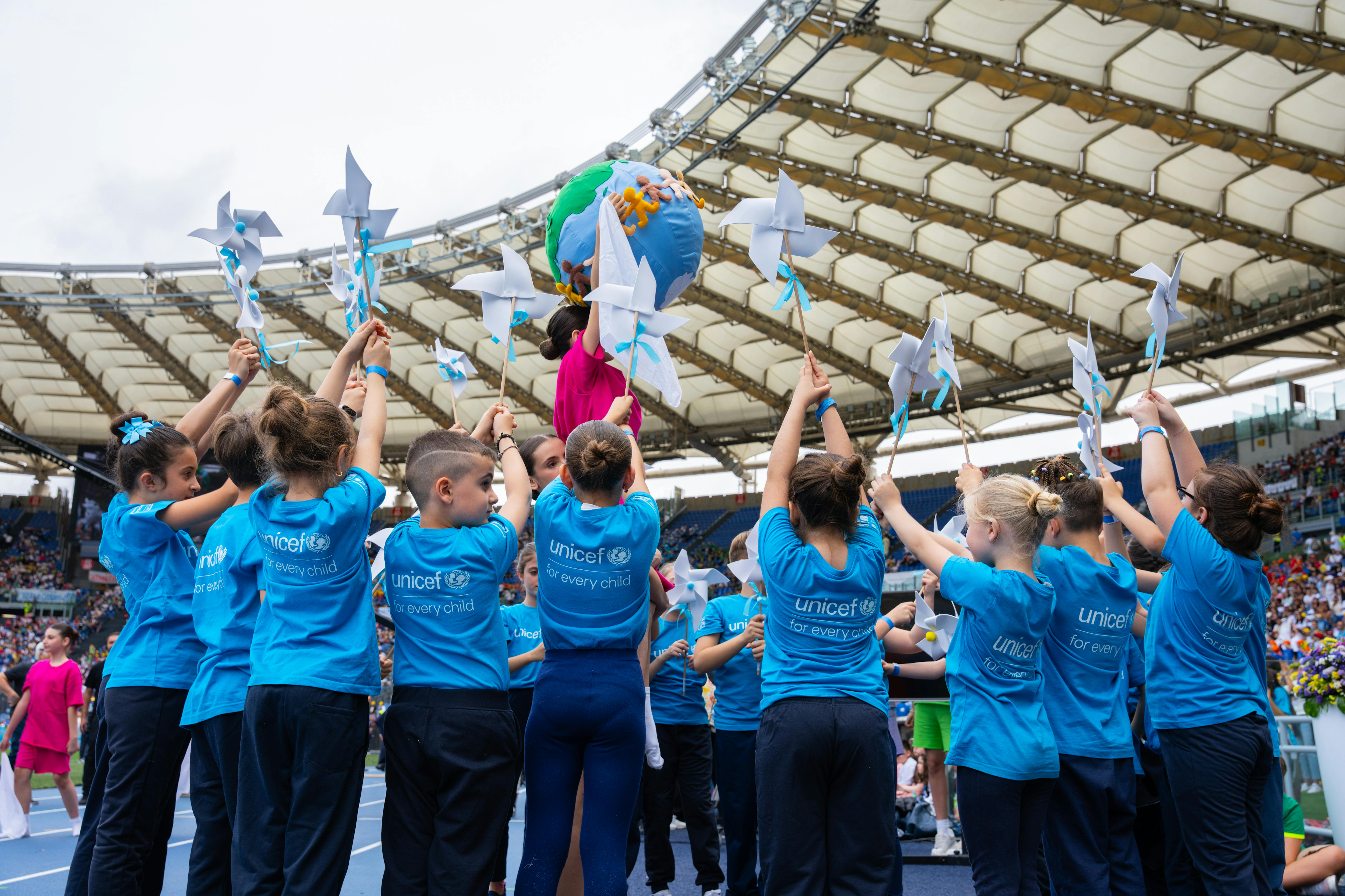 Stadio olimpico, bambini tengono un mondo e girandole Stadio olimpico, bambini tengono un mondo e girandole
