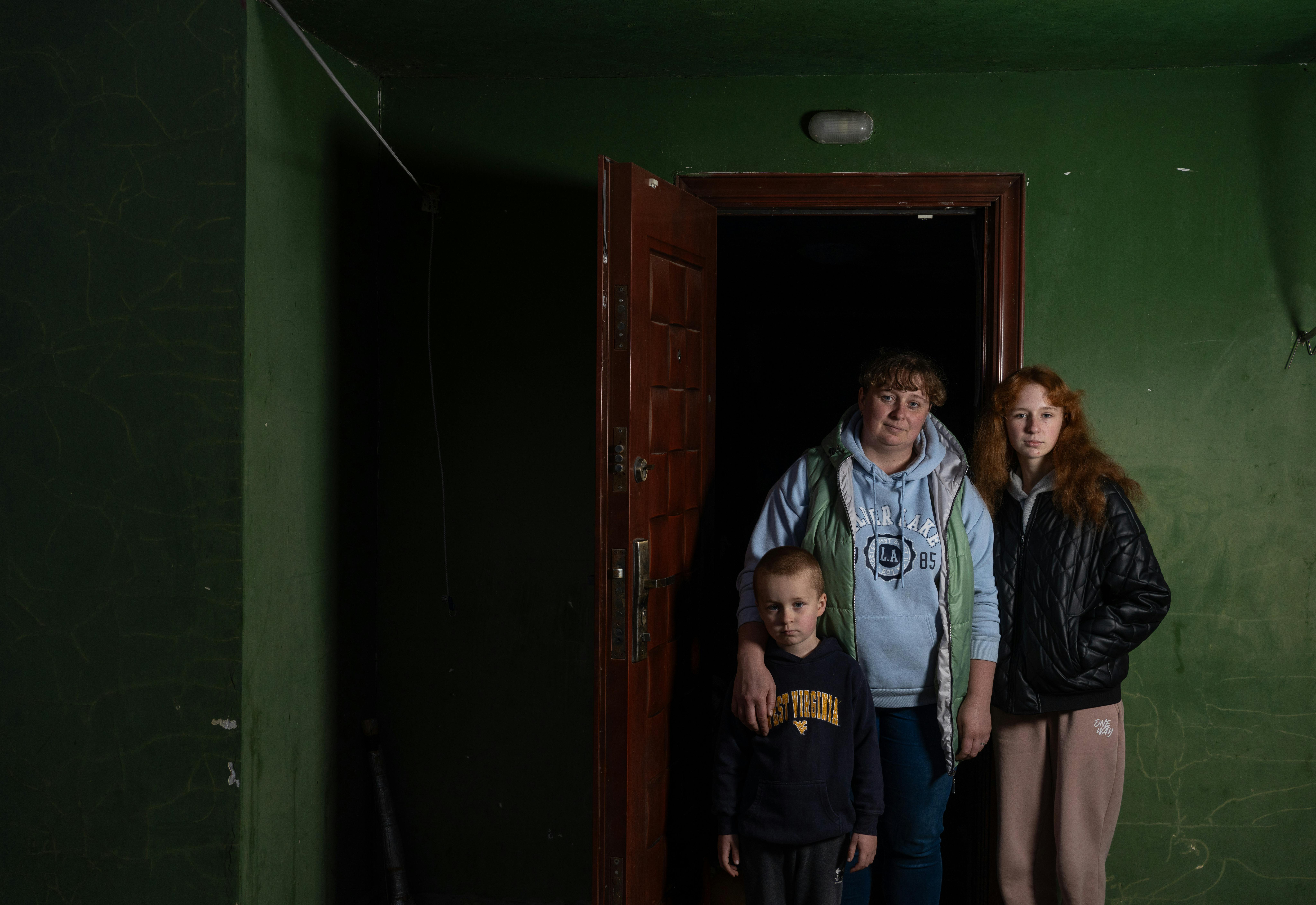 Khotimlya, regione di Kharkiv. Andriy, Hayla e la loro mamma Katya posano davanti alla casa dove si sono rifugiati insieme alla madre. La guerra in Ucraina li ha costretti a spostarsi diverse volte e vivere in una perenne situazione di stress