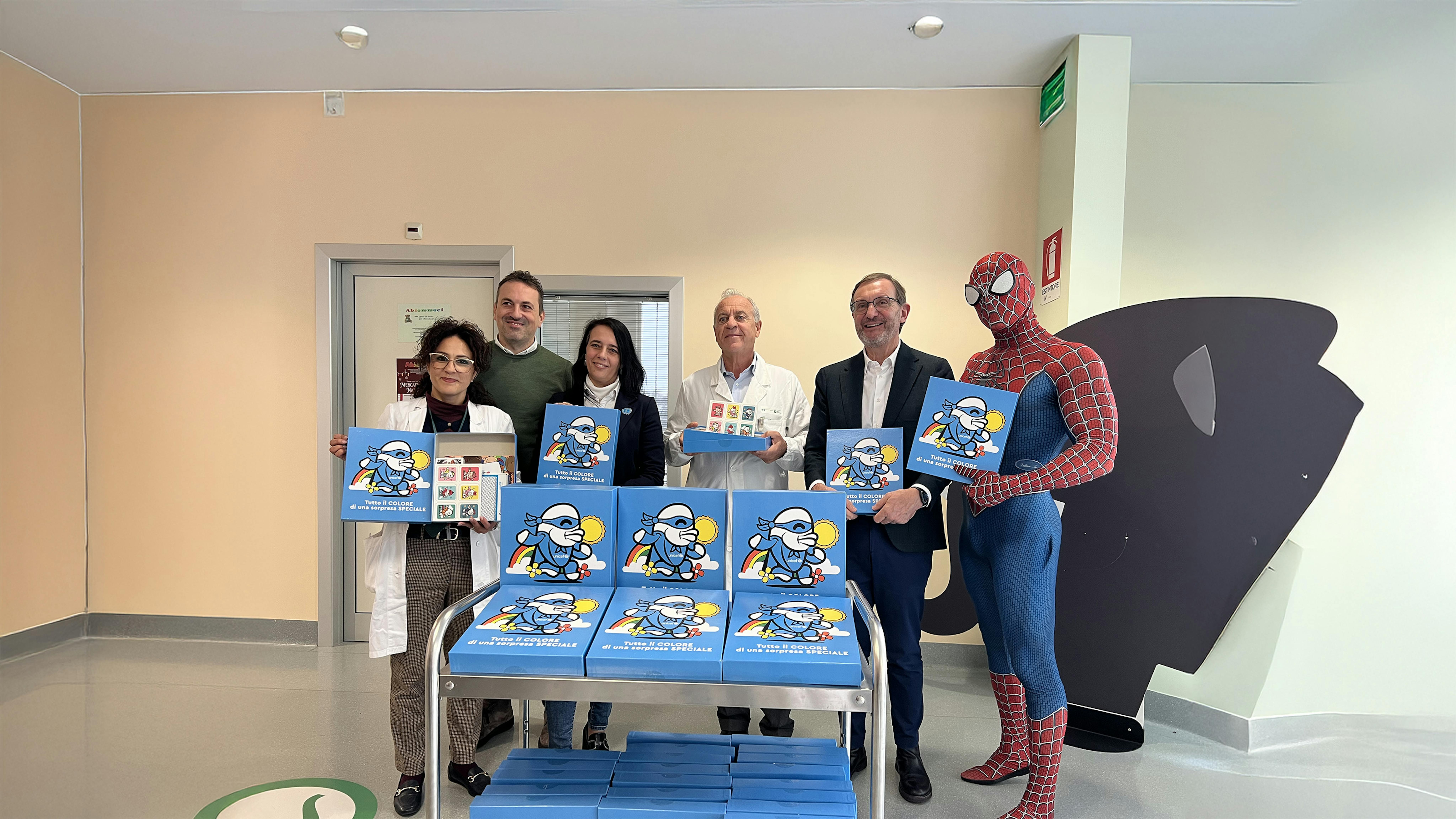 Staff UNICEF e del'Ospedale, Pierpaolo Clementoni e Spiderman in posa con il Regalo sospeso