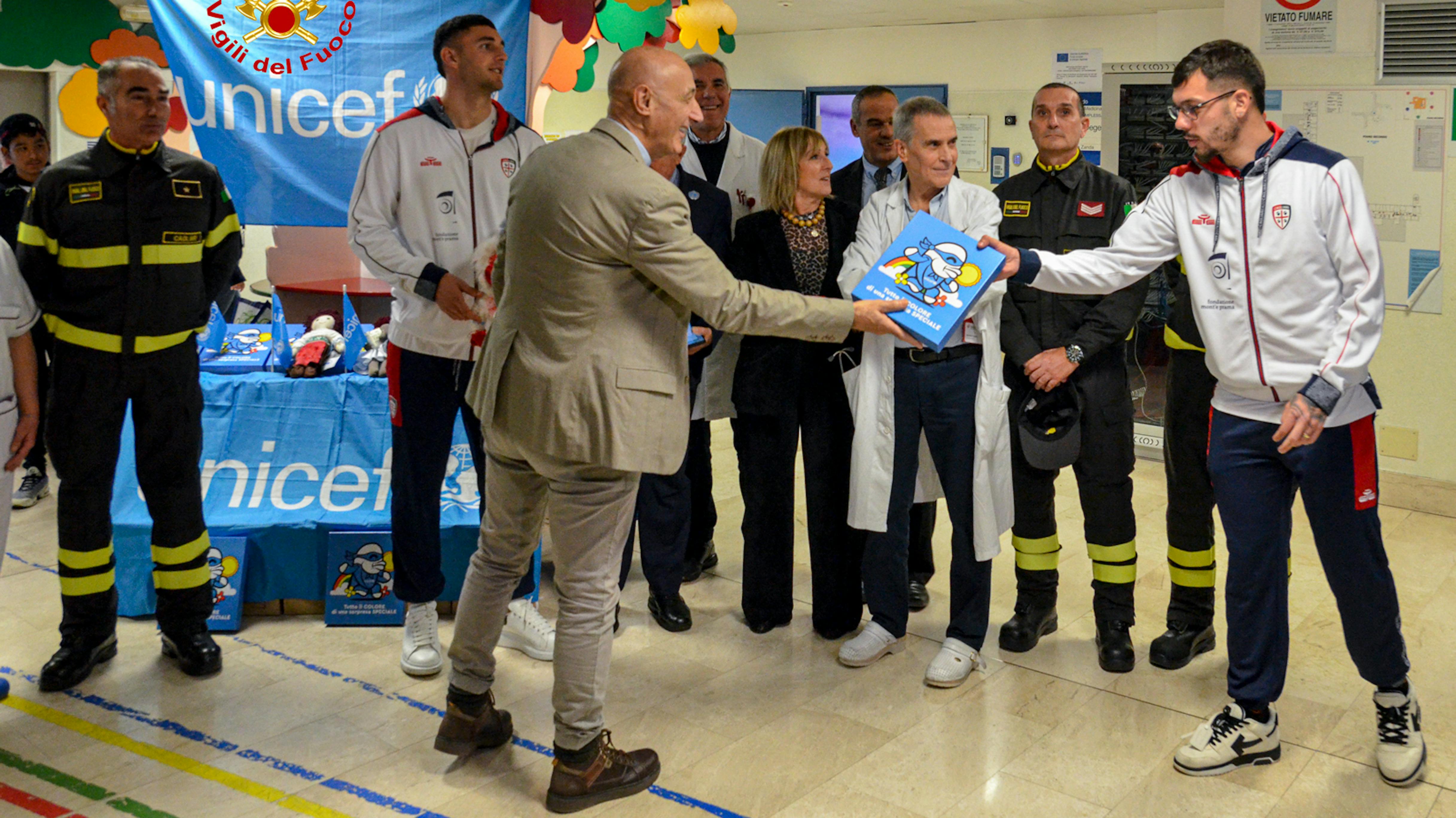 Cagliari, i giocatori del Cagliari e i Vigili del Fuoco, ambiasciatori UNICEF, durante la consegna del Regalo Sospeso