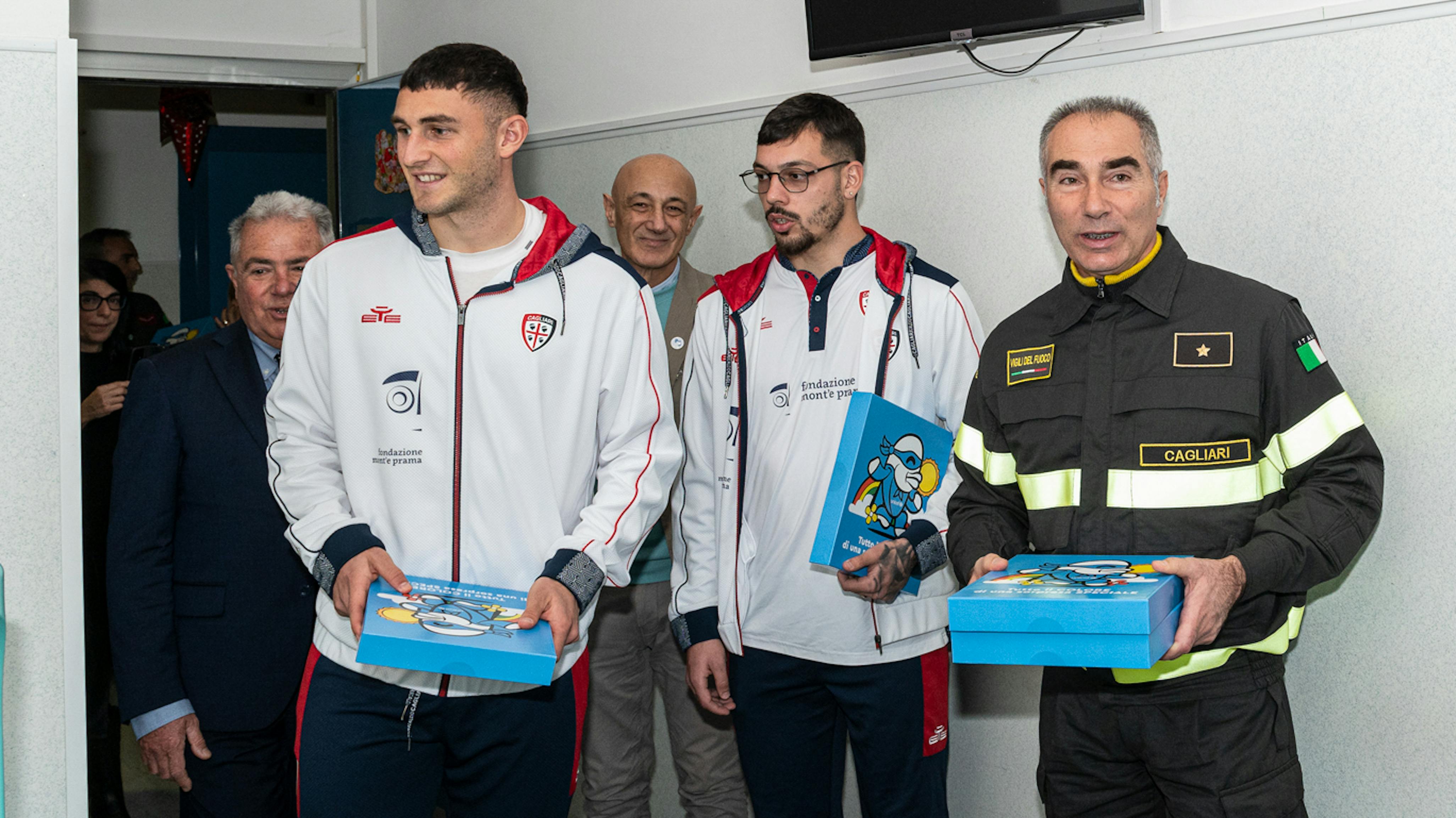 I giocatori de Cagliari e i Vigili del fuoco nell'ospedale ARNAS G.Brotzu  di Cagliari durante la consegna del regalo sospeso