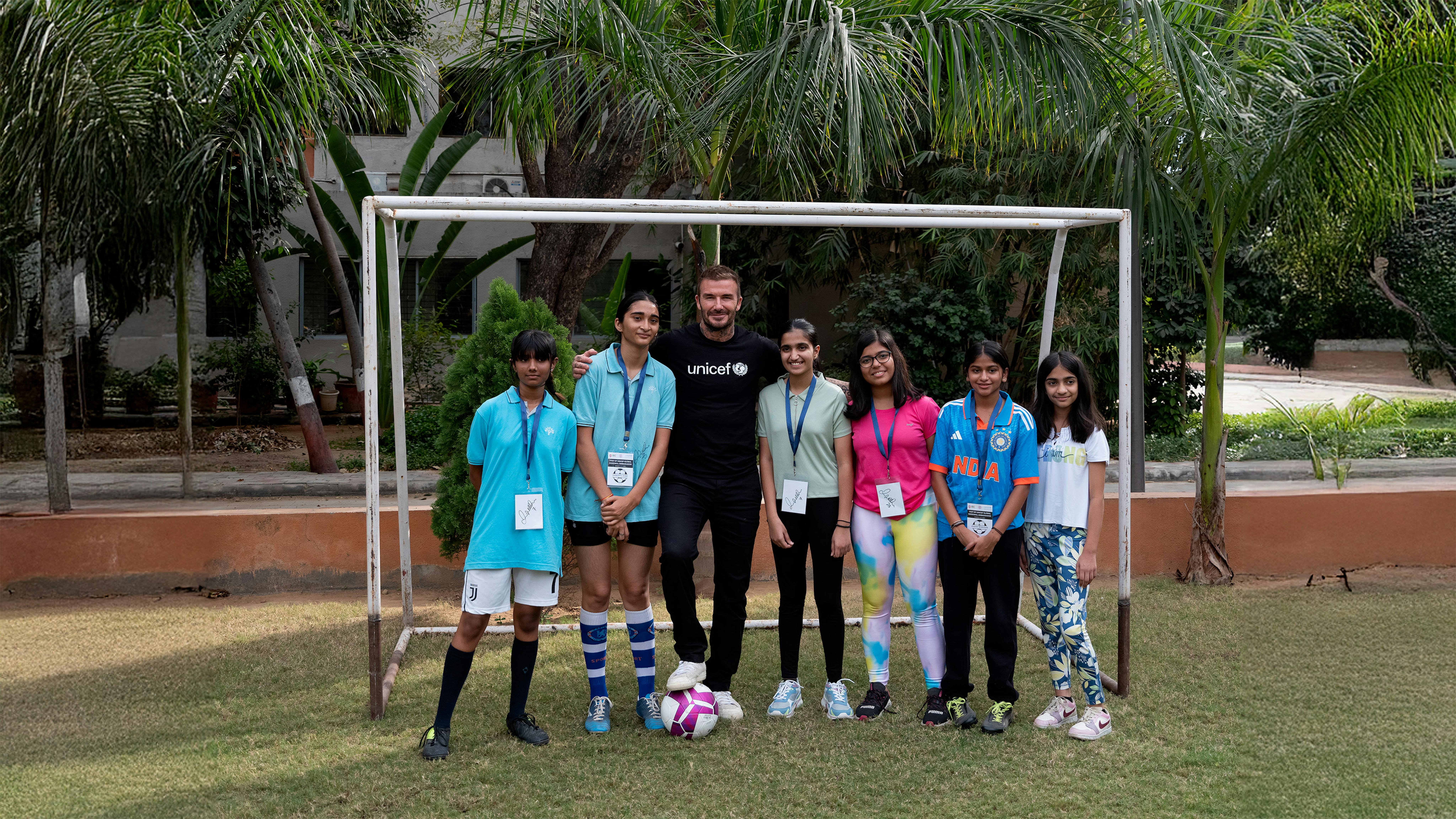 Il 13 novembre 2023 in India, l'Ambasciatore di buona volontà dell'UNICEF David Beckham (in maglietta dell'UNICEF) posa con i bambini dopo aver giocato un'amichevole di calcio all'Università del Gujarat ad Ahmedabad.