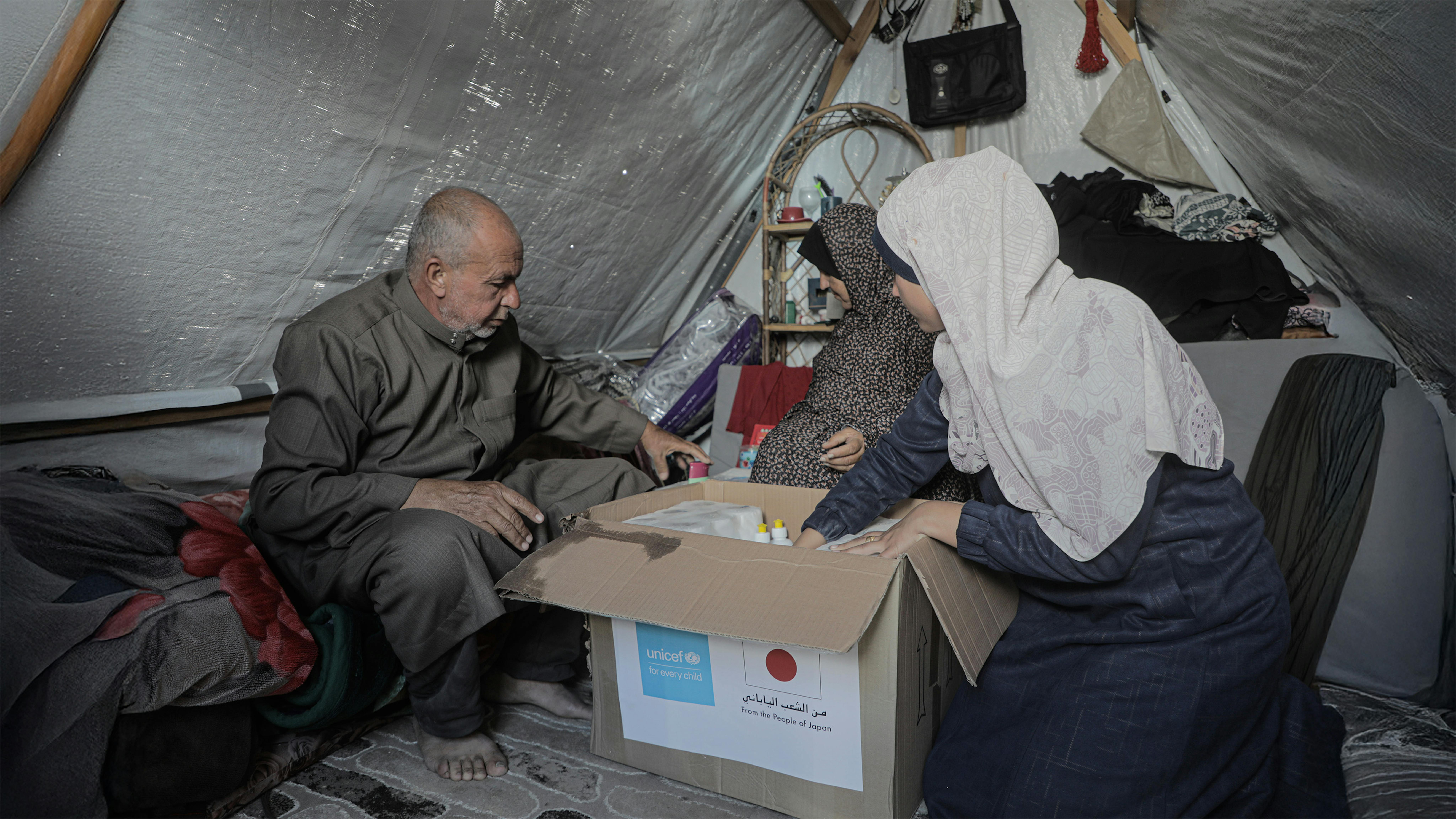 Stato di Palestina, Mahmoud, sua moglie Haniya e un altro membro della famiglia disimballano un kit per l'igiene distribuito alle famiglie di Khan Younis, nel centro di Gaza