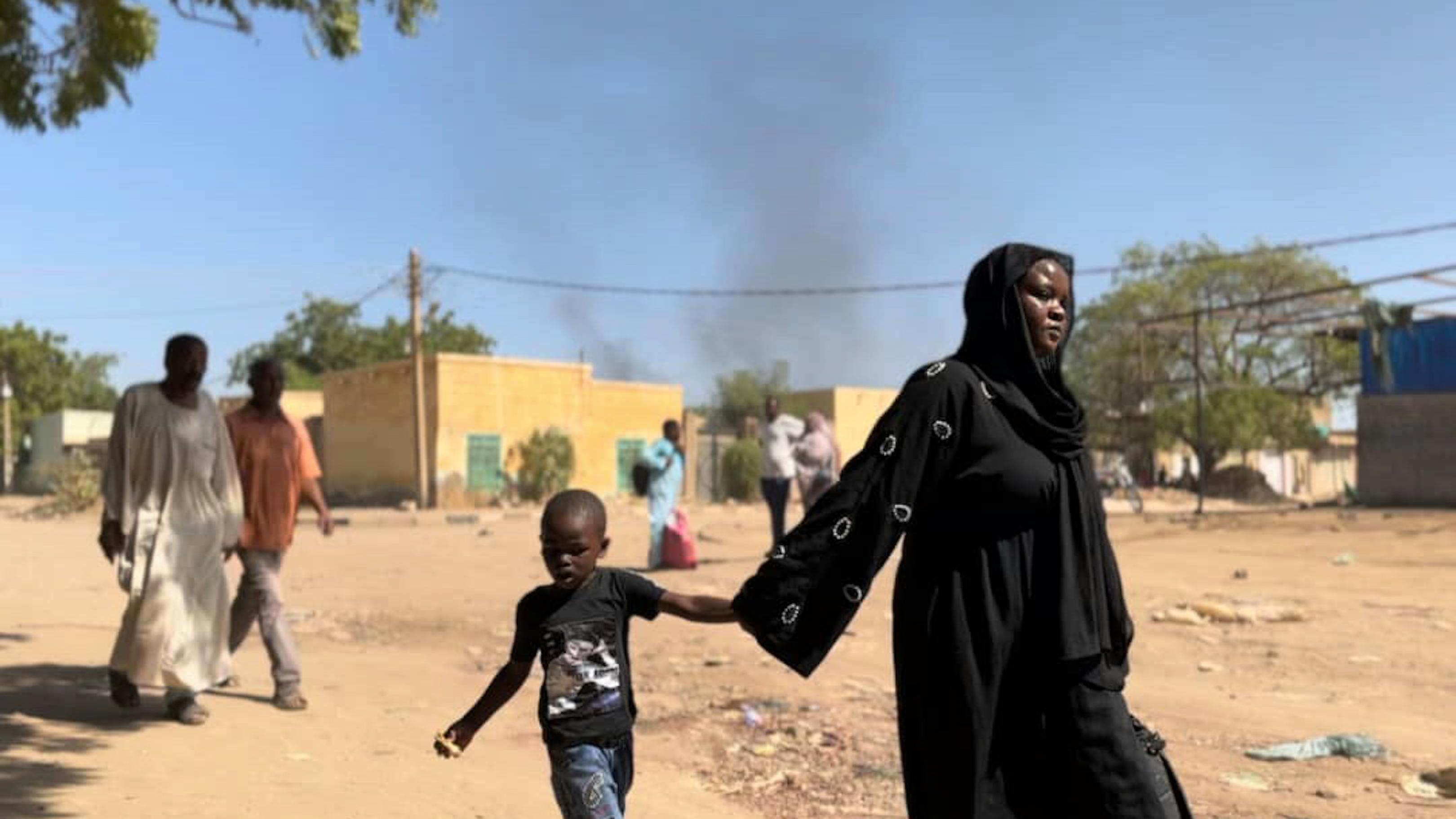 Bambini e famiglie fuggono a piedi da Wad Madani, nello stato di Al Jazirah, in seguito ai recenti scontri.