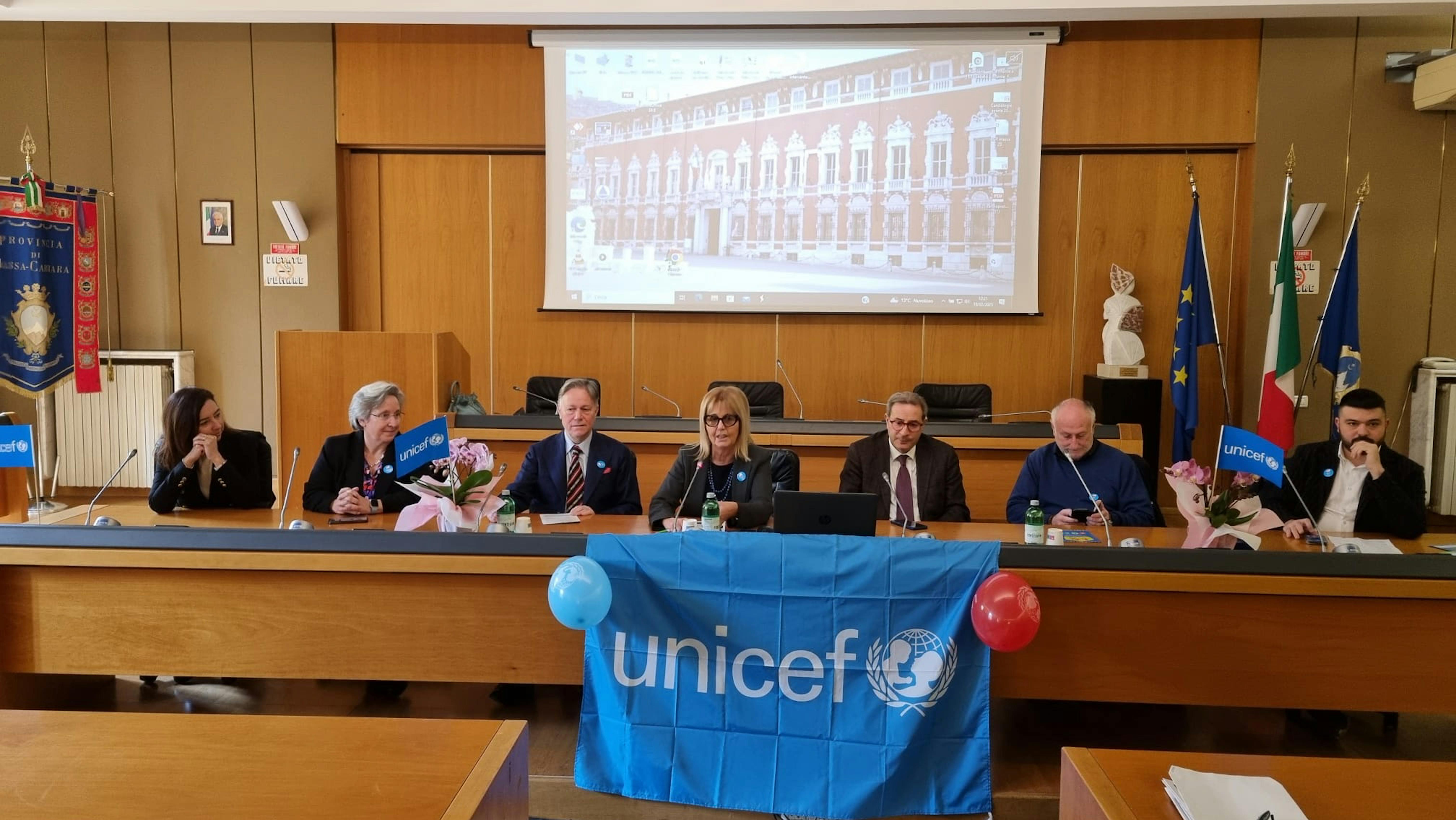 da sinistra  2  rappresentanti UNICEF Elise Chapin e Stefania Solare, Roberto Valettini (presidente della Società della Salute della Lunigiana), Monica Guglielmi (direttrice Zona distretto Apuane), Guido Aprea (prefetto di Massa e Carrara), Gianni Lorenzetti (presidente Provincia Massa e Carrara), Francesco Mangiaracina (assessore Politiche sociali Comune di Massa).