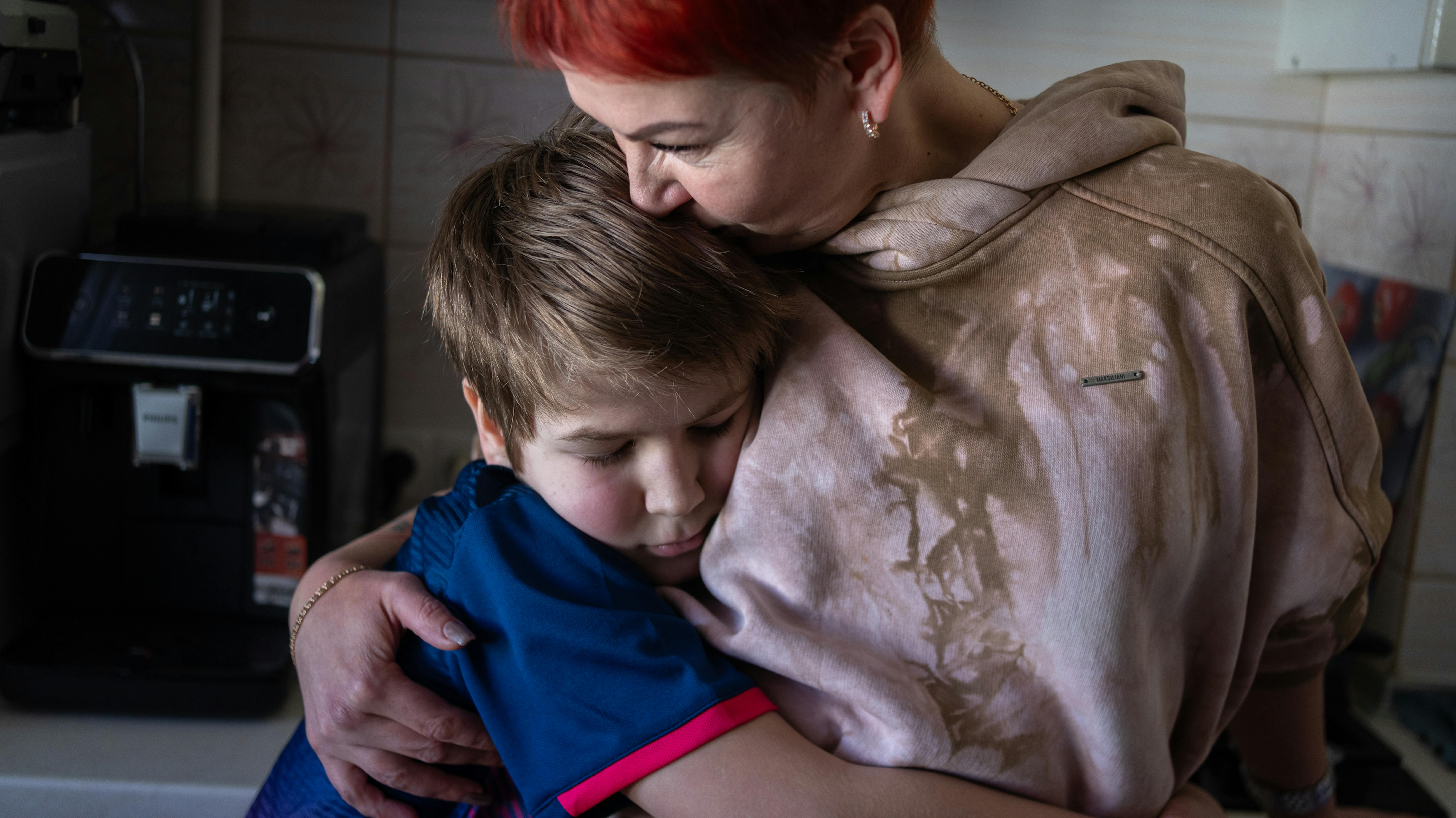 Ucraina - Andrii, 10 anni, abbraccia sua madre nella loro cucina a Kherson. Dopo aver perso il padre lo scorso inverno,