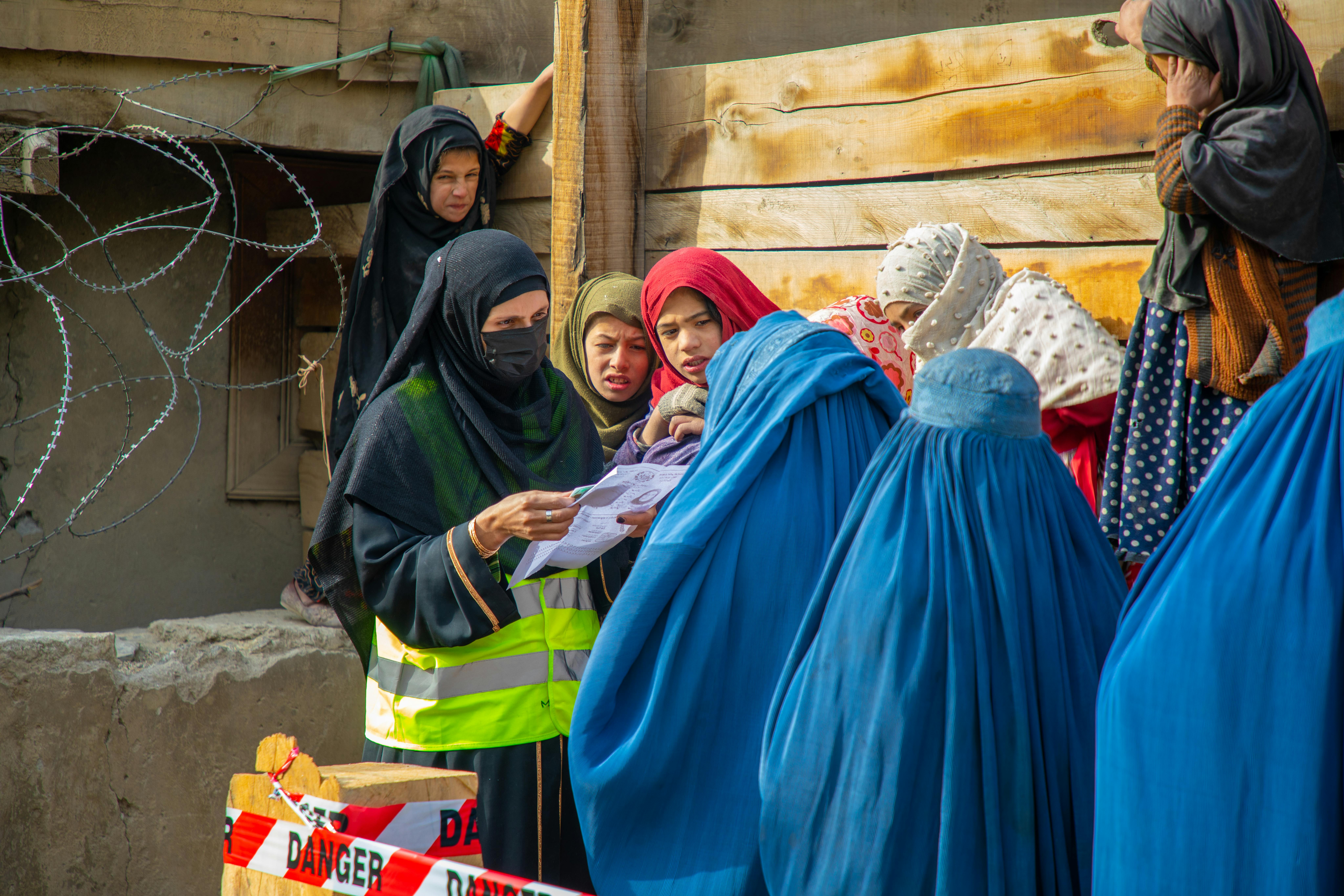 Maryam sta controllando i documenti d'identità delle donne che ricevono assistenza in denaro nel villaggio di Sharqi, nel Nuristan, in Afghanistan