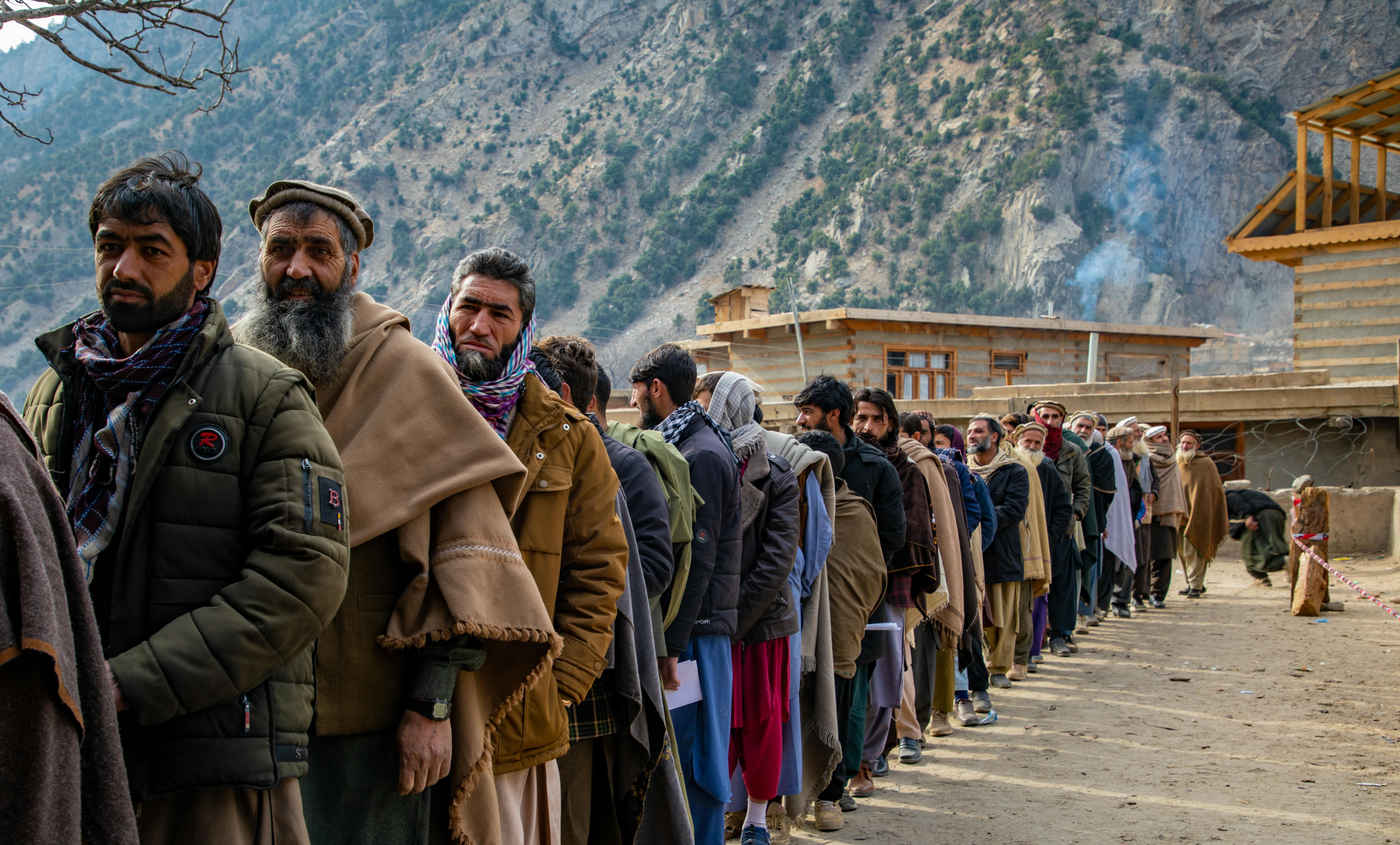 Uomini in fila per ricevere il sostegno in denaro che l'UNICEF sta distribuendo nel Nuristan, una delle provincie meno servite dell'Afghanistan, con il più alto tasso di povertà multidimensionale.