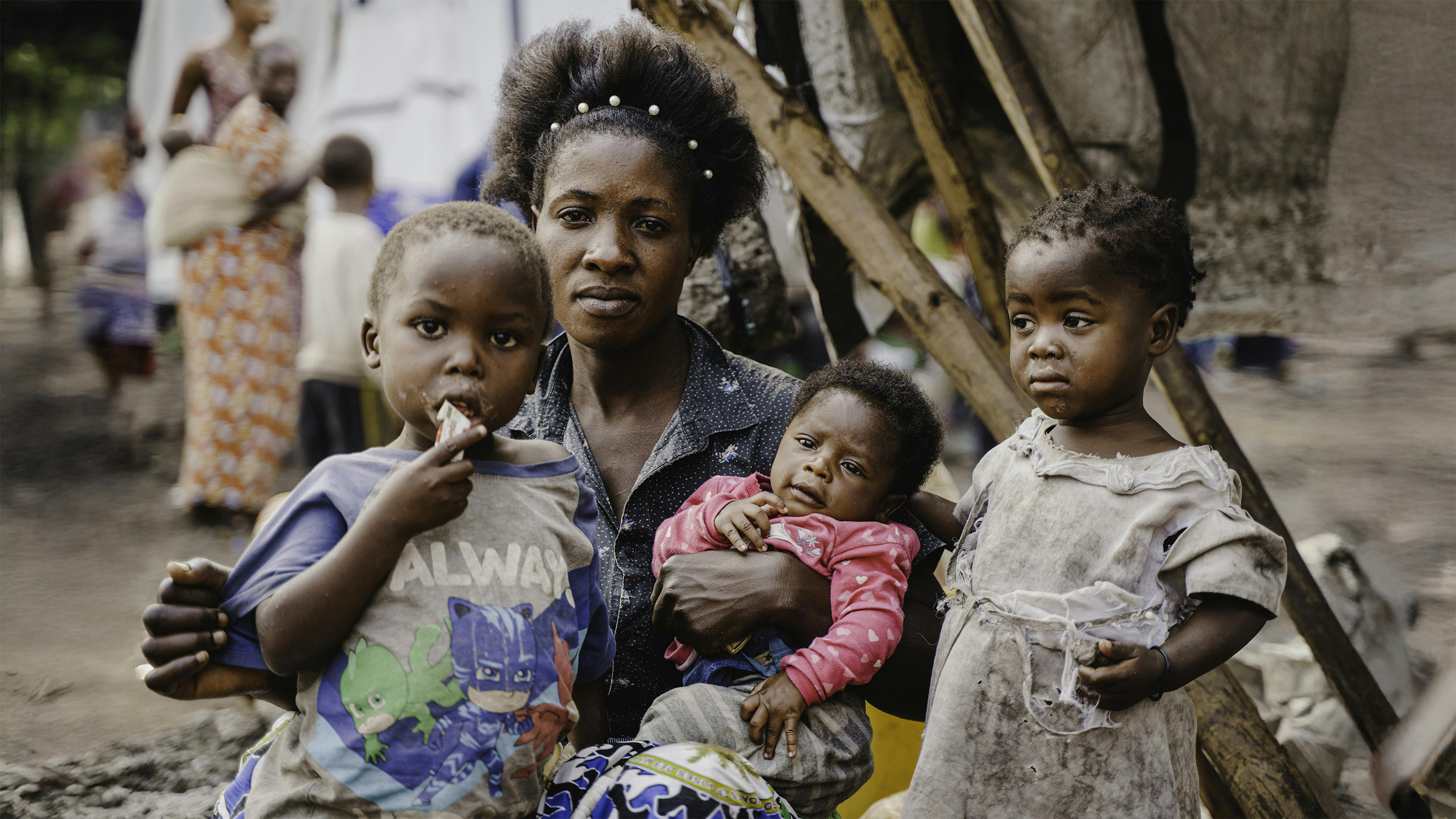Masika Mukize siede con i suoi figli davanti al loro rifugio di fortuna a Goma, nella provincia del Nord Kivu, nella Repubblica Democratica del Congo