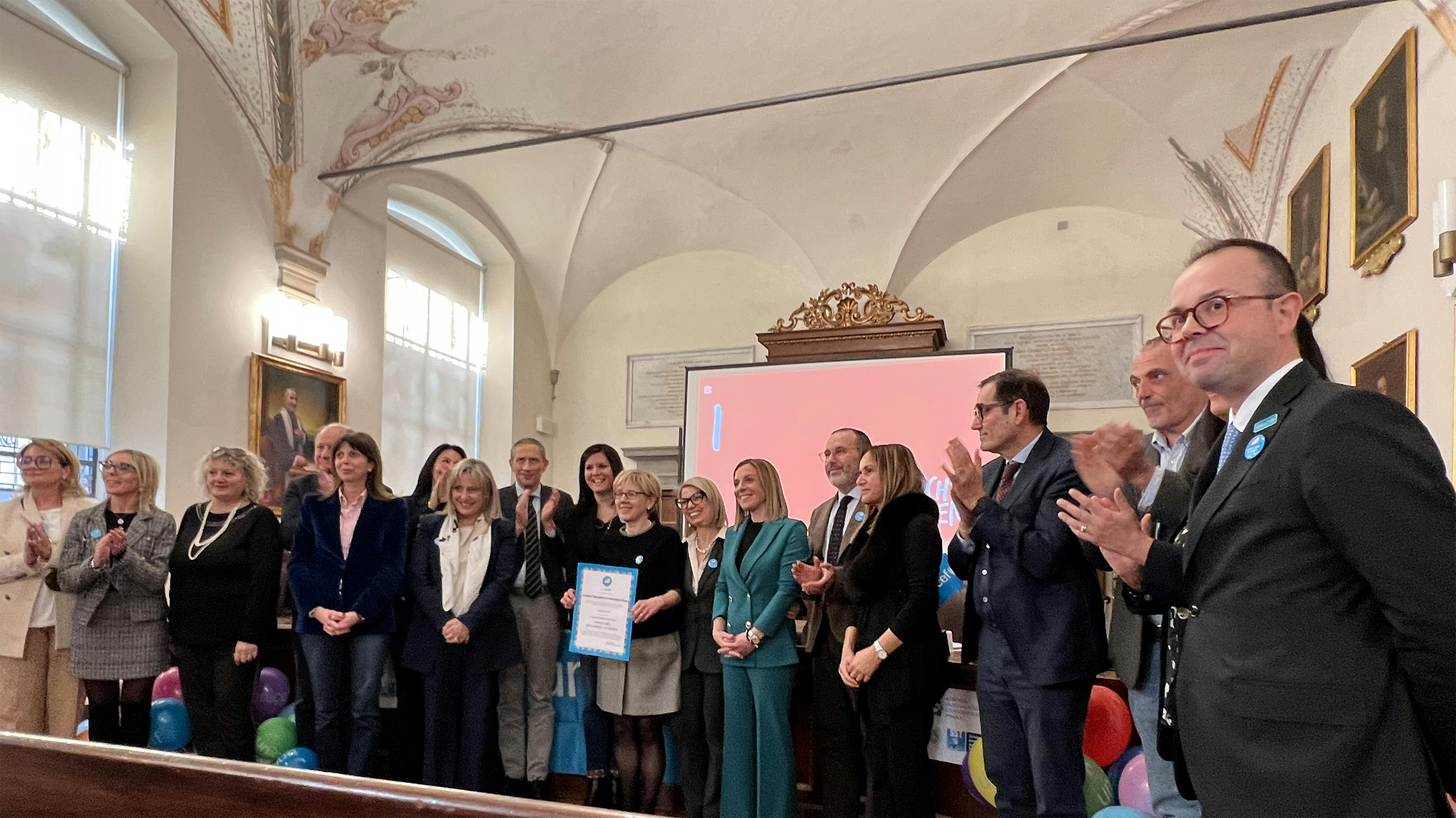 il momento della consegna. Il nuovo presidente del Comitato di Pisa è il 1° a destra. La Direttrice Generale Briani tiene in mano la pergamena
