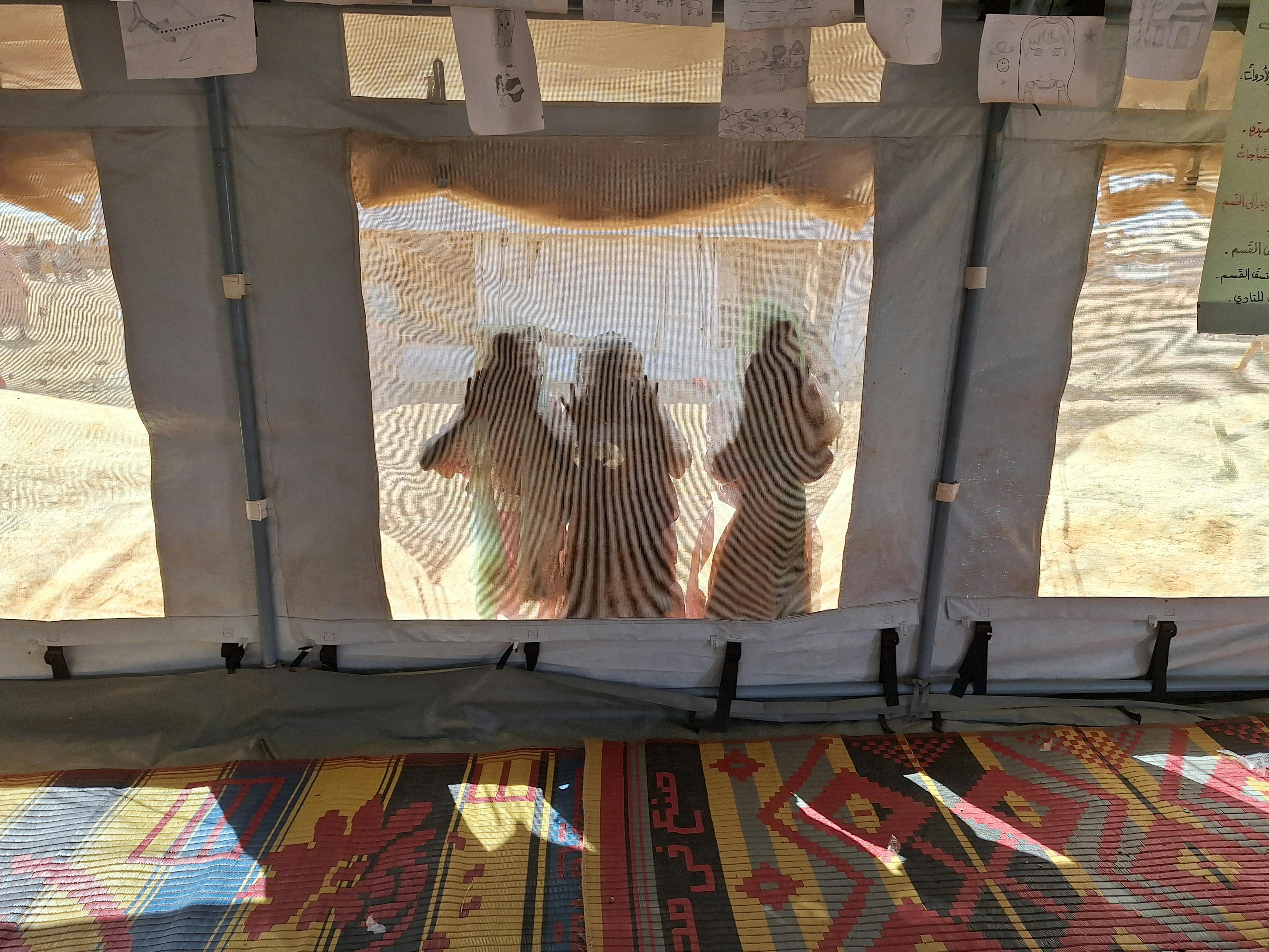 Il 3 dicembre 2024, alcuni bambini sbirciano attraverso una tenda dell'UNICEF uno spazio a misura di bambino (CFS) nello stato di Kassala, in Sudan.